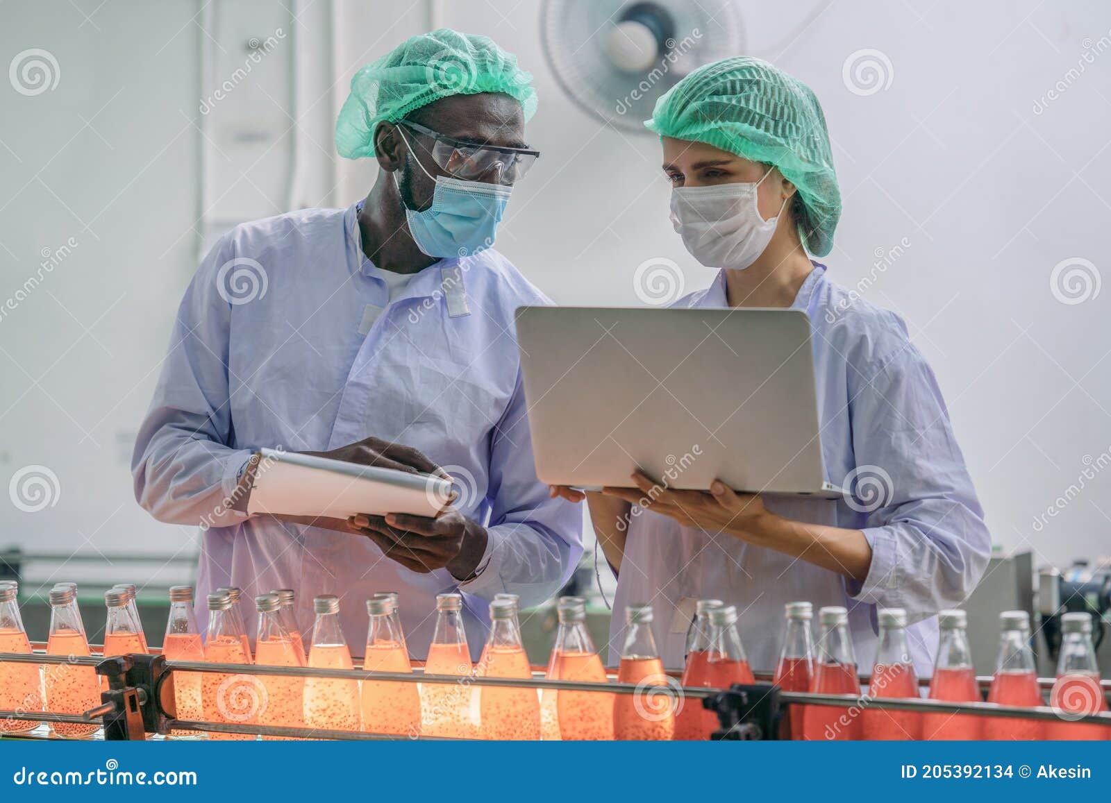 production line supervisor and worker work together in beverage production line