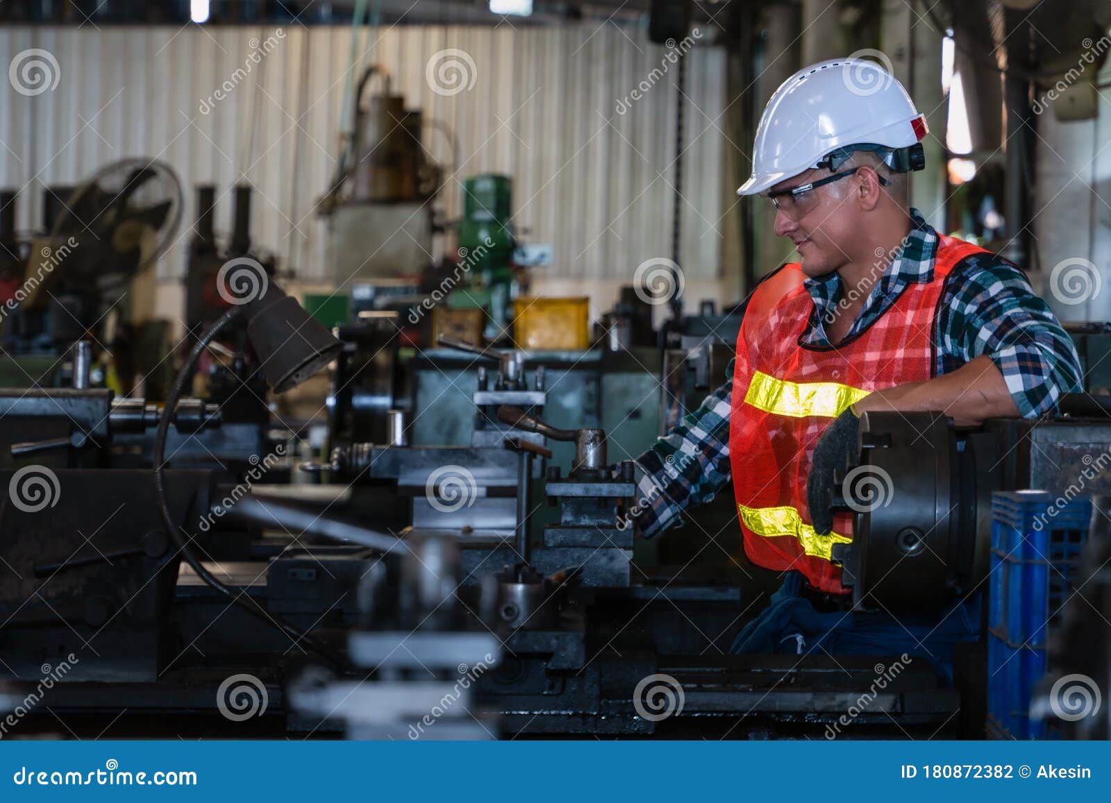 industrial background of caucasian mechanic engineer with lathe machine in metal work and machine part manufacturer workshop and