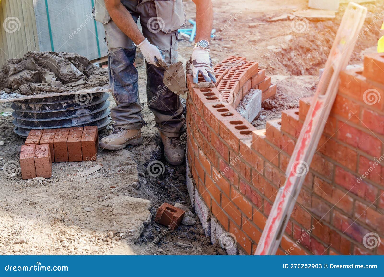 Industrial Bricklayer Laying Bricks on Cement Mix on Construction Site