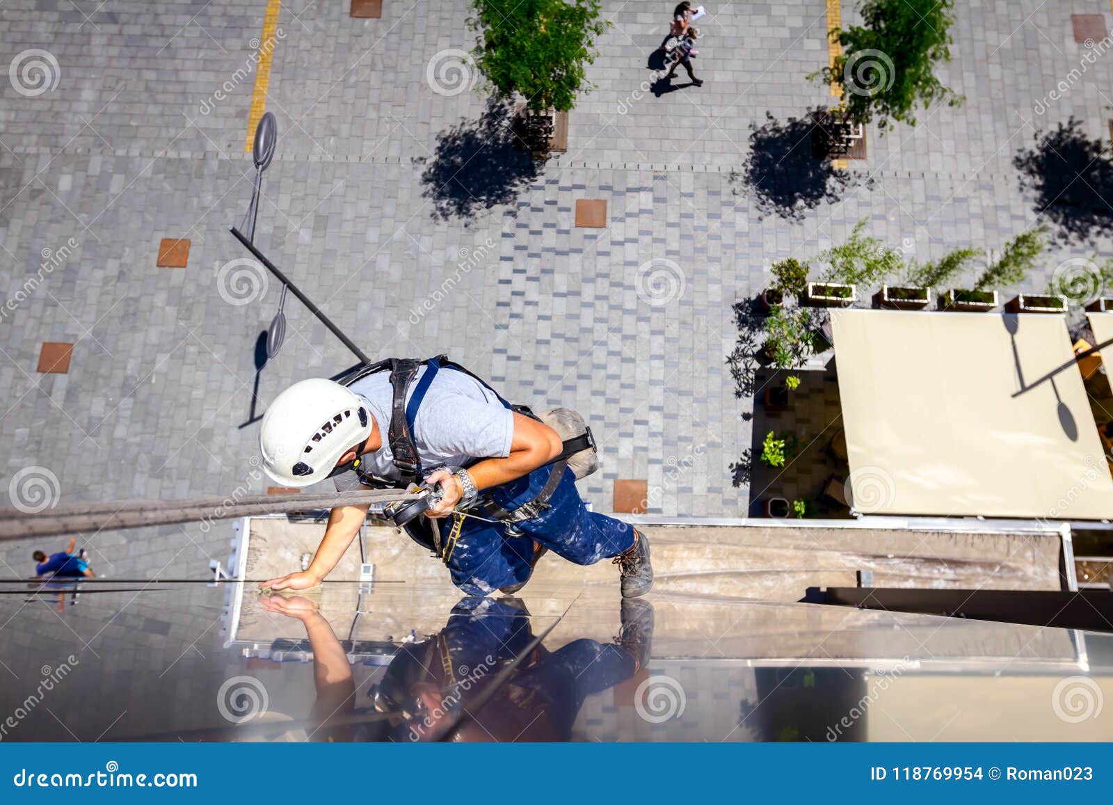 industrial climber is washing, cleaning facade of a modern office building