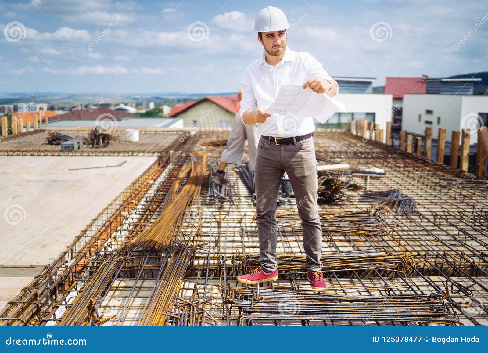 Engineer, Architect Wearing Hardhat and Protective Gear Supervising Construction Site Stock