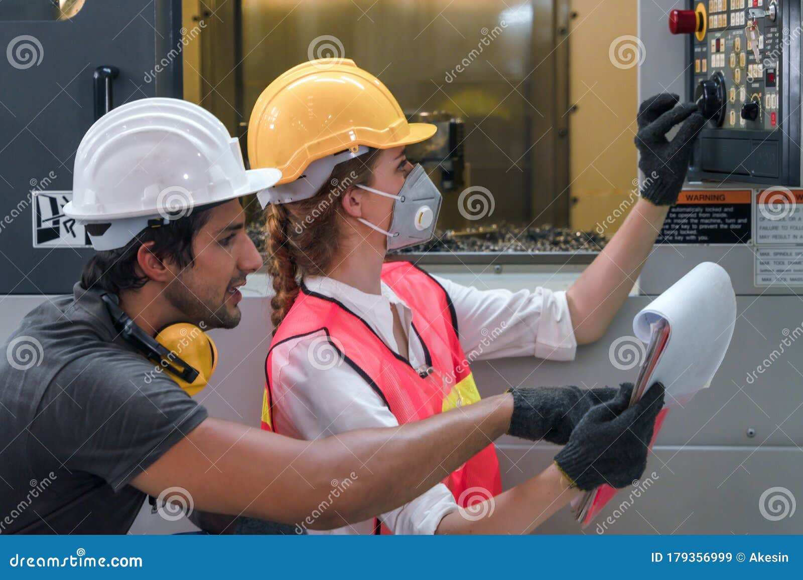 industrial or factory engineering worker and supervisor setting up computerized control panel of factory assembly line controller