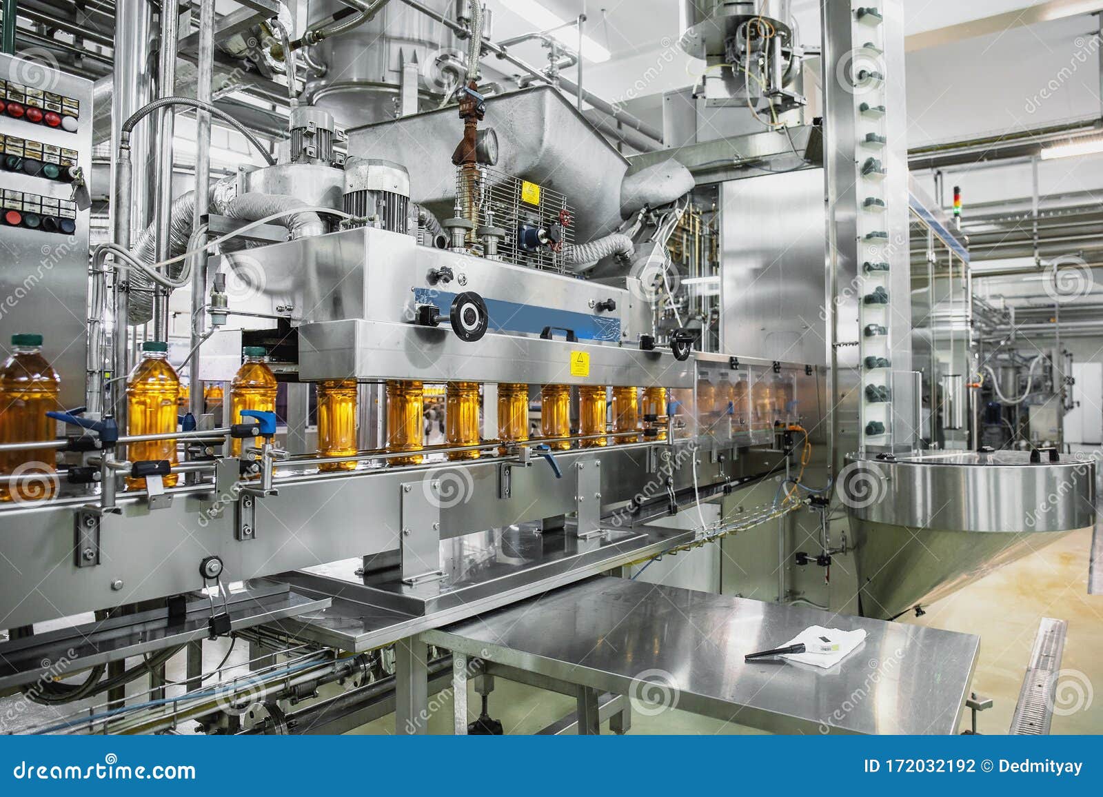 industrial interior of natural juice plant production. conveyor belt, filled bottles on beverage factory, industry