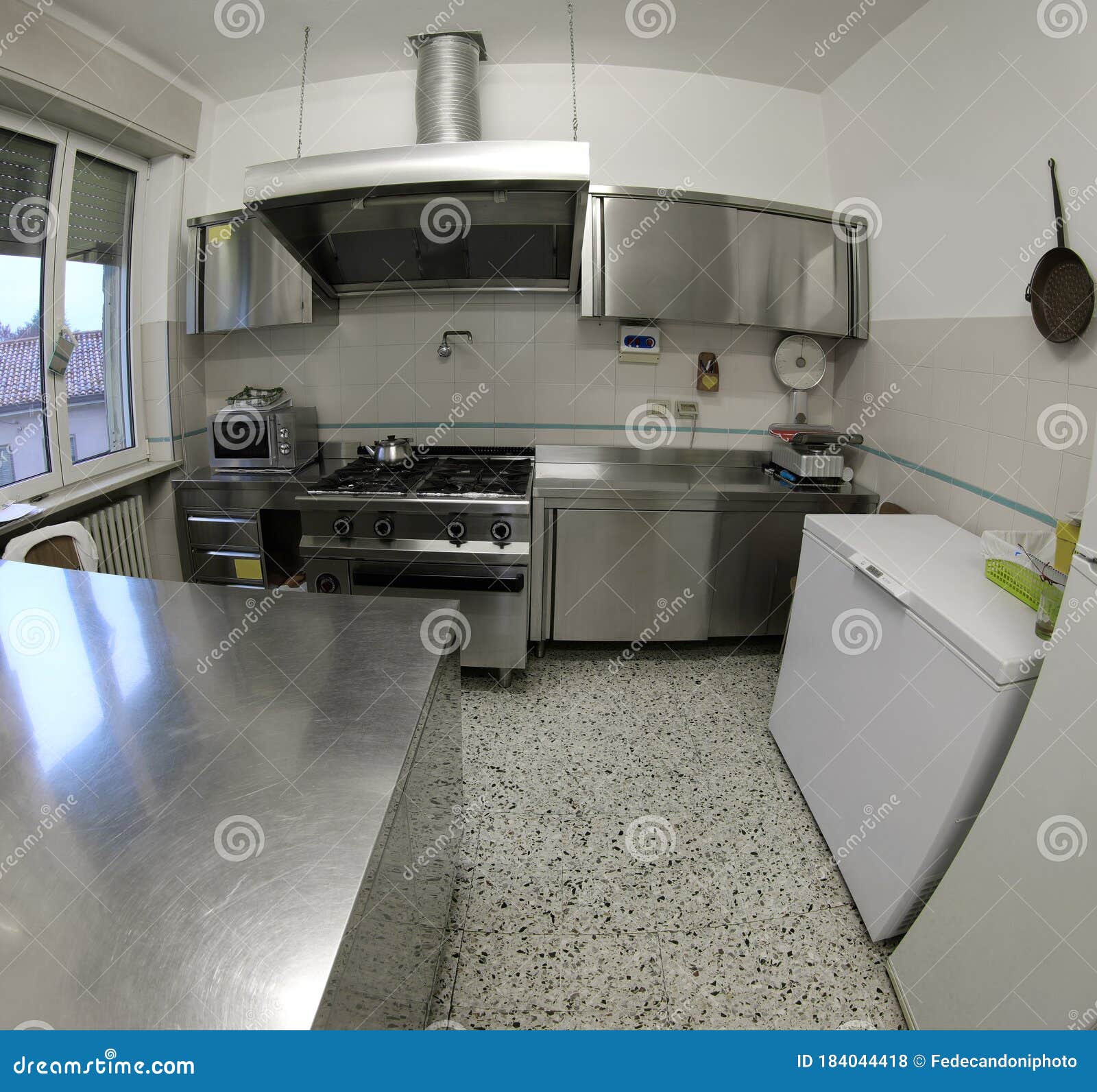 industrial kitchen with stainless steel stove and large extracto