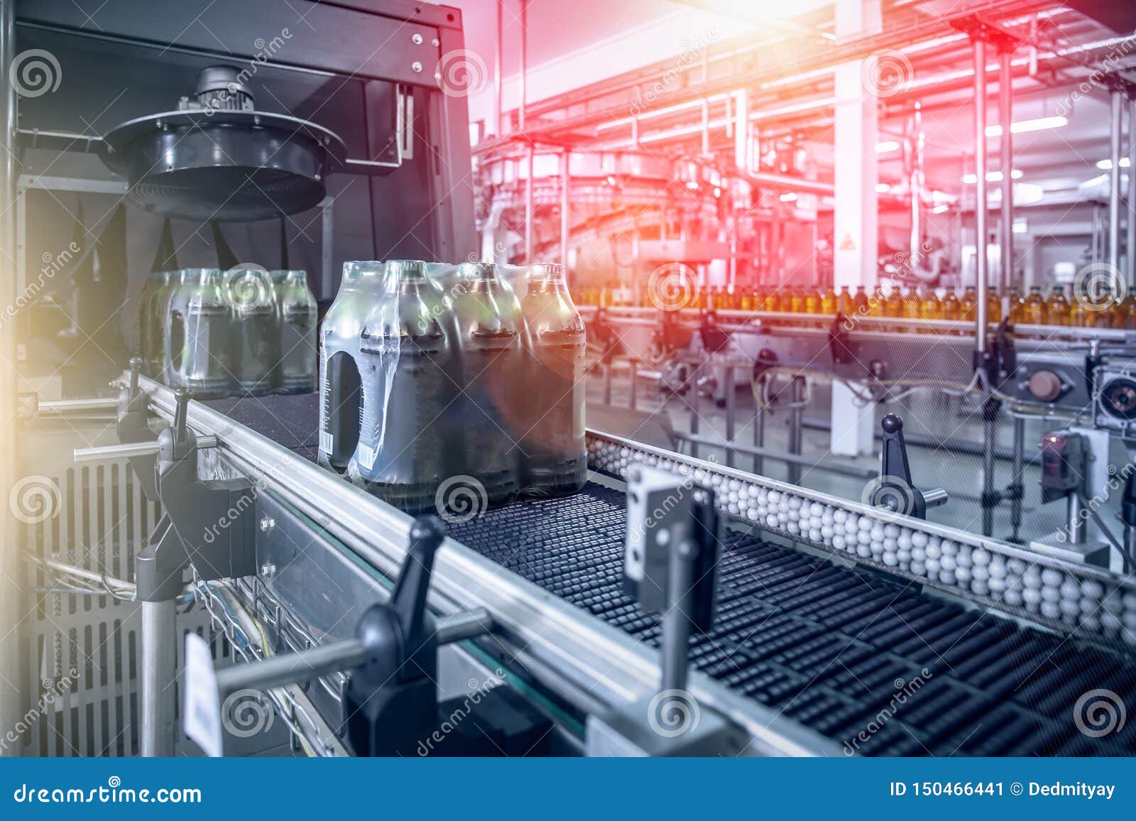 industrial machine for packaging of beverage plastic bottles at plant or factory, blue toned as abstract industry background