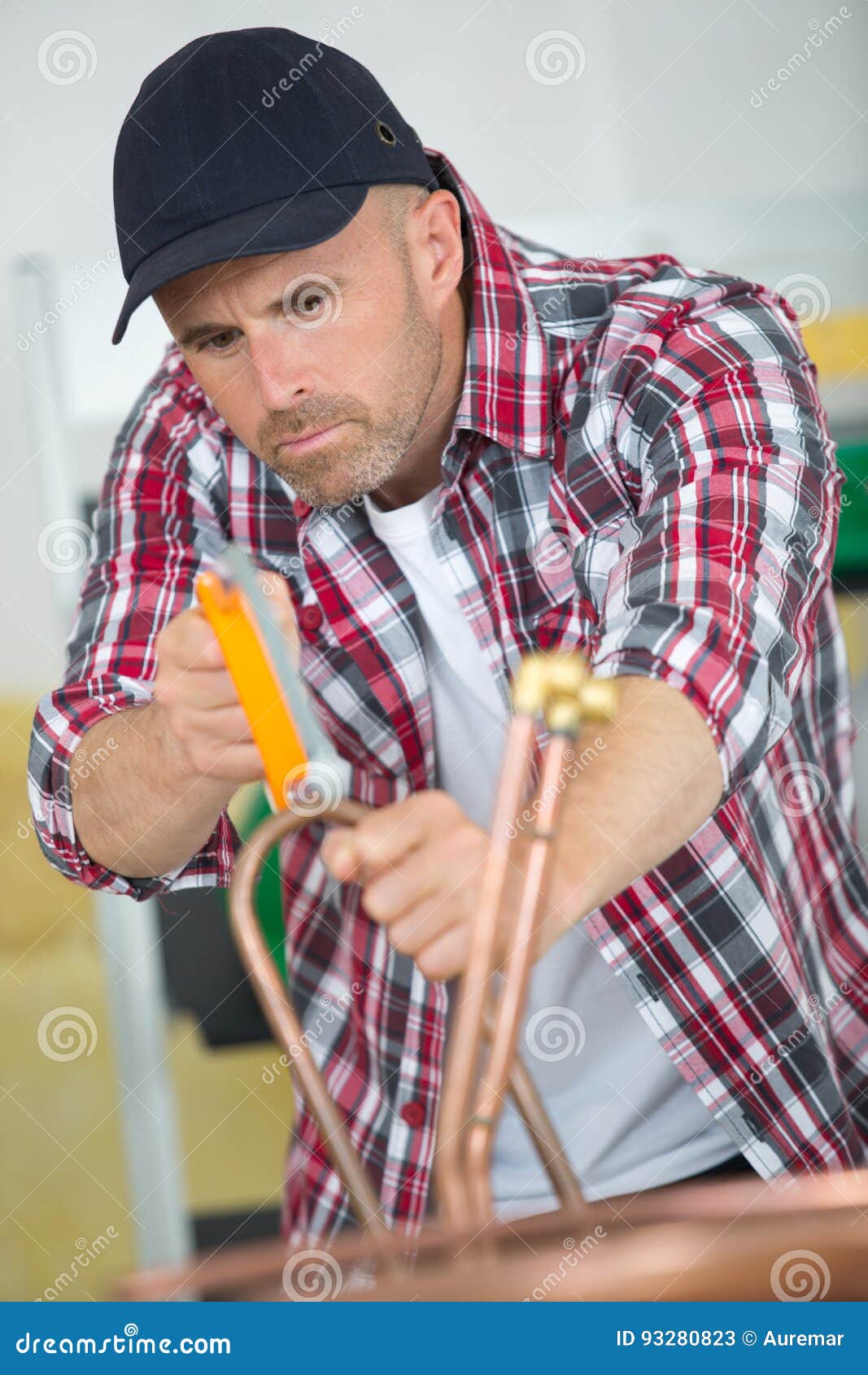 Industrial Plumber Cutting Copper Pipe with Pipe Cutter Stock Image