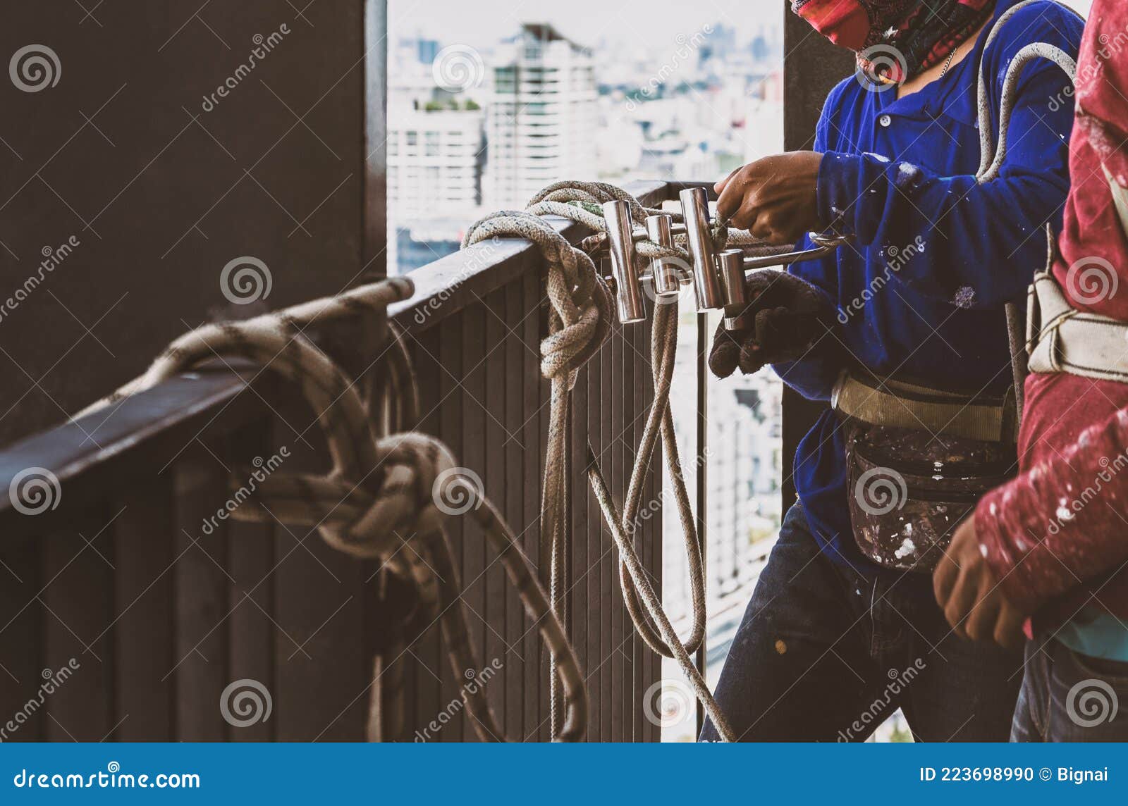 Industrial Worker Adjusting Climbing Gear Preparing Safety Rope. Stock