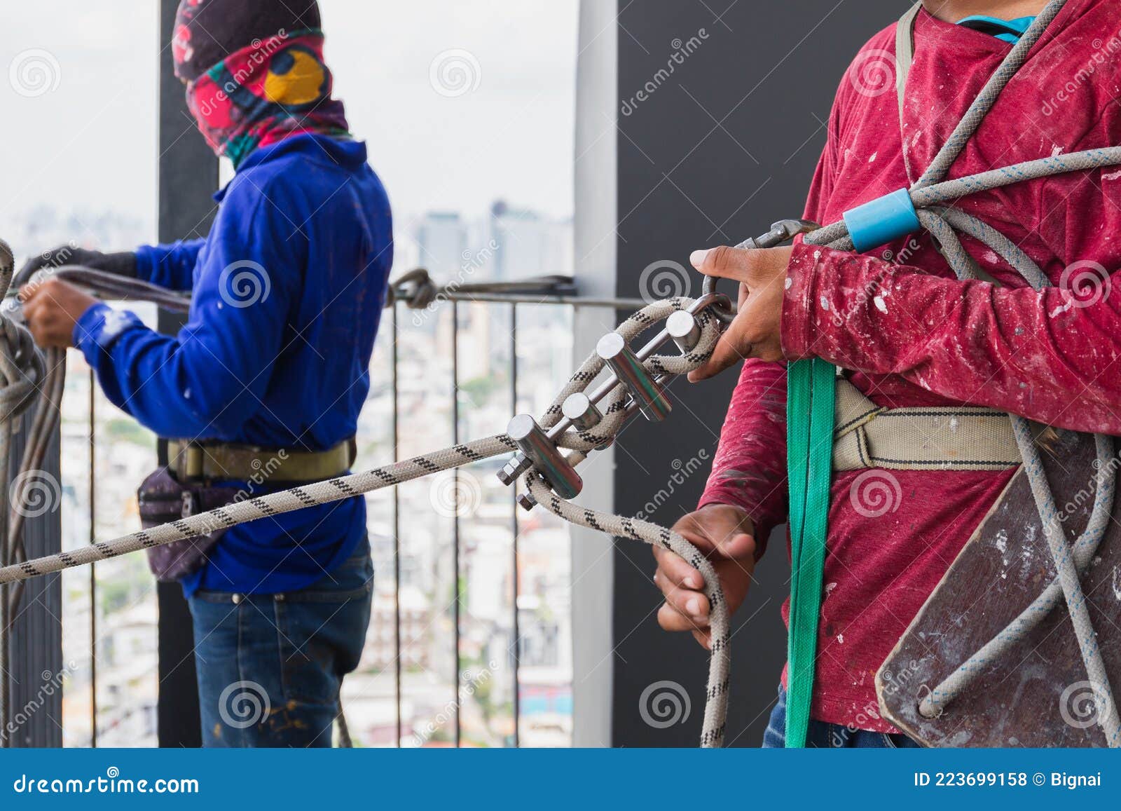 Industrial Worker Adjusting Climbing Gear Preparing Safety Rope. Stock