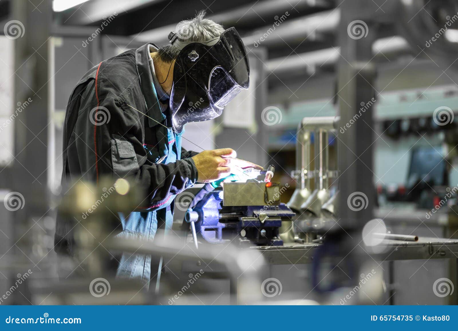 industrial worker welding in metal factory.
