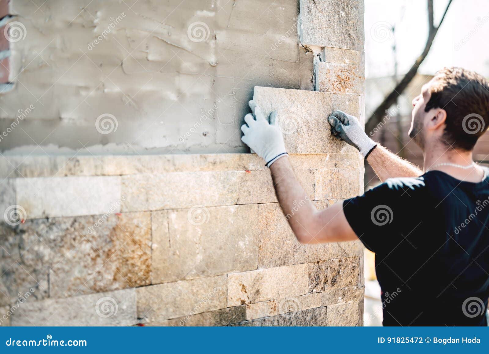 Industry Worker Installing Stone Tiles on Architectural House Facade