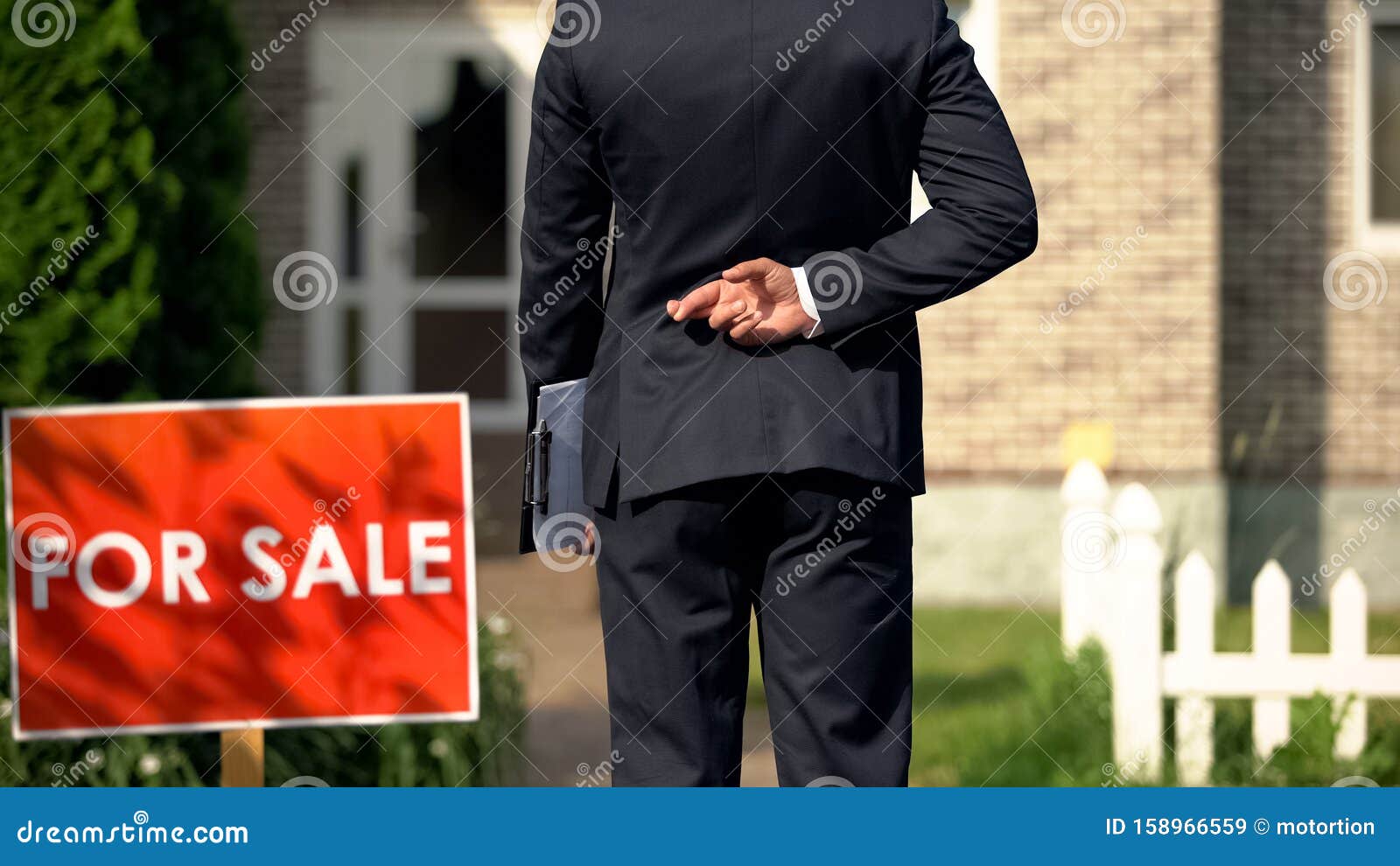 inexperienced broker crossing fingers behind his back before selling house, luck