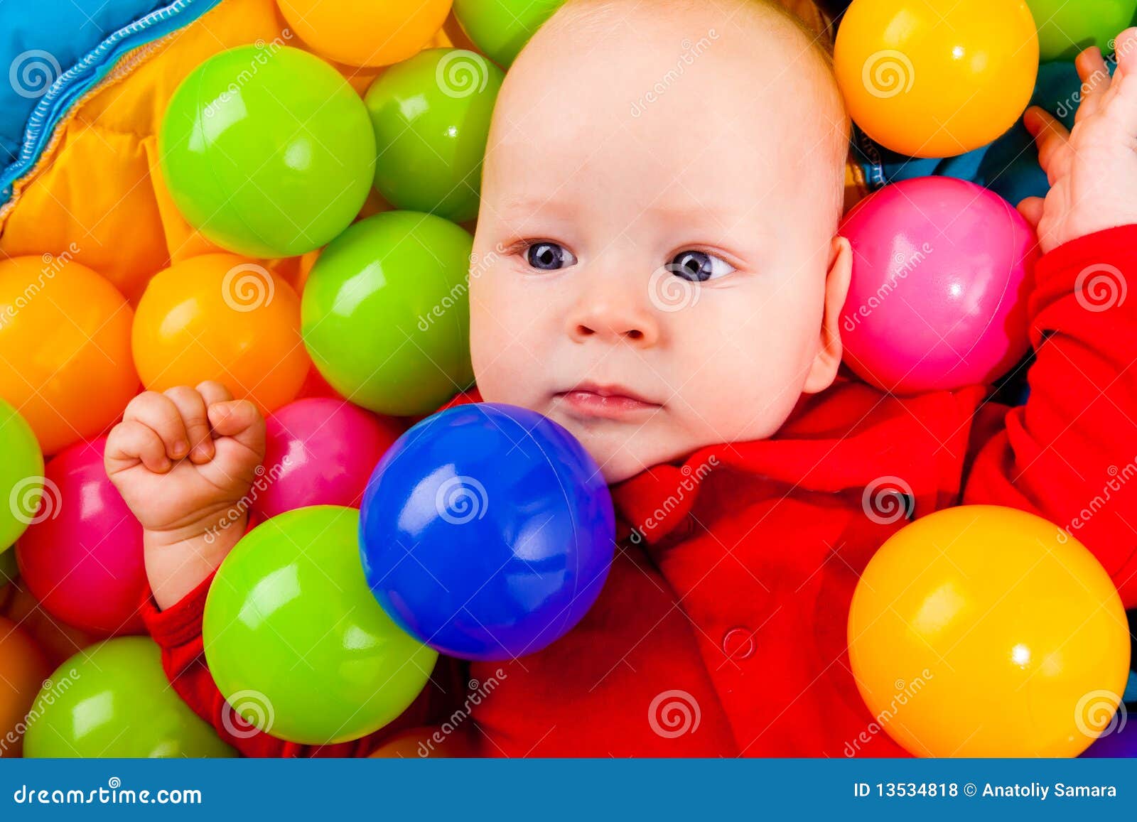 Infant with colorful balls stock photo. Image of colorful 13534818