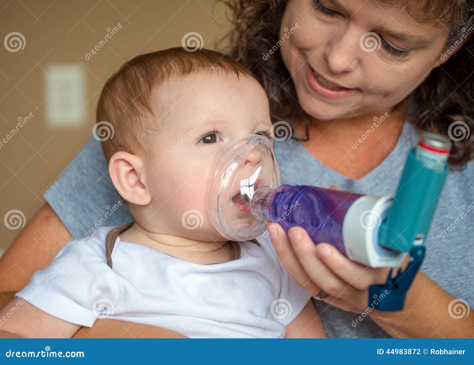infant getting breathing treatment from mother
