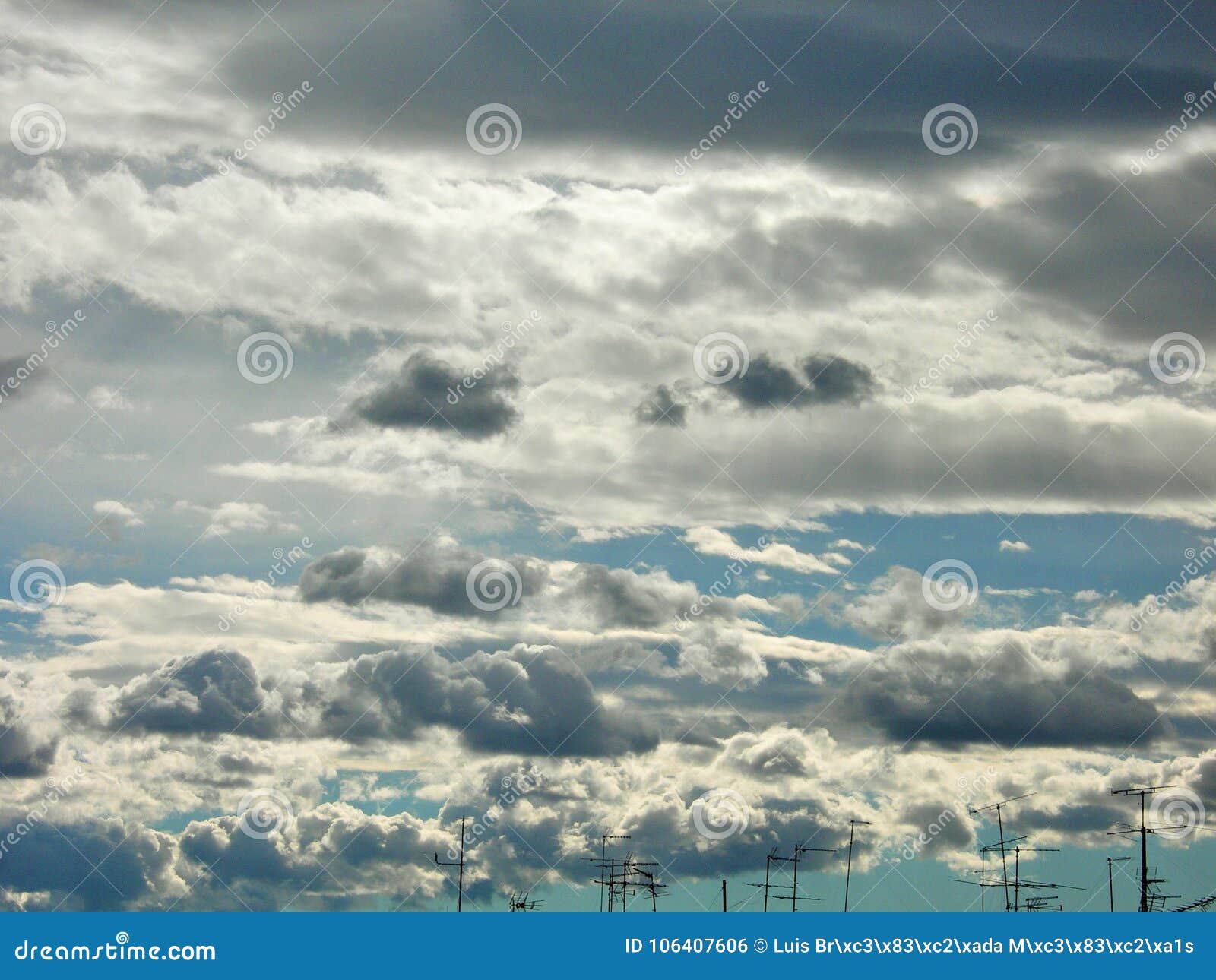 antennas skyline under white clouds flying. stratocumulus.