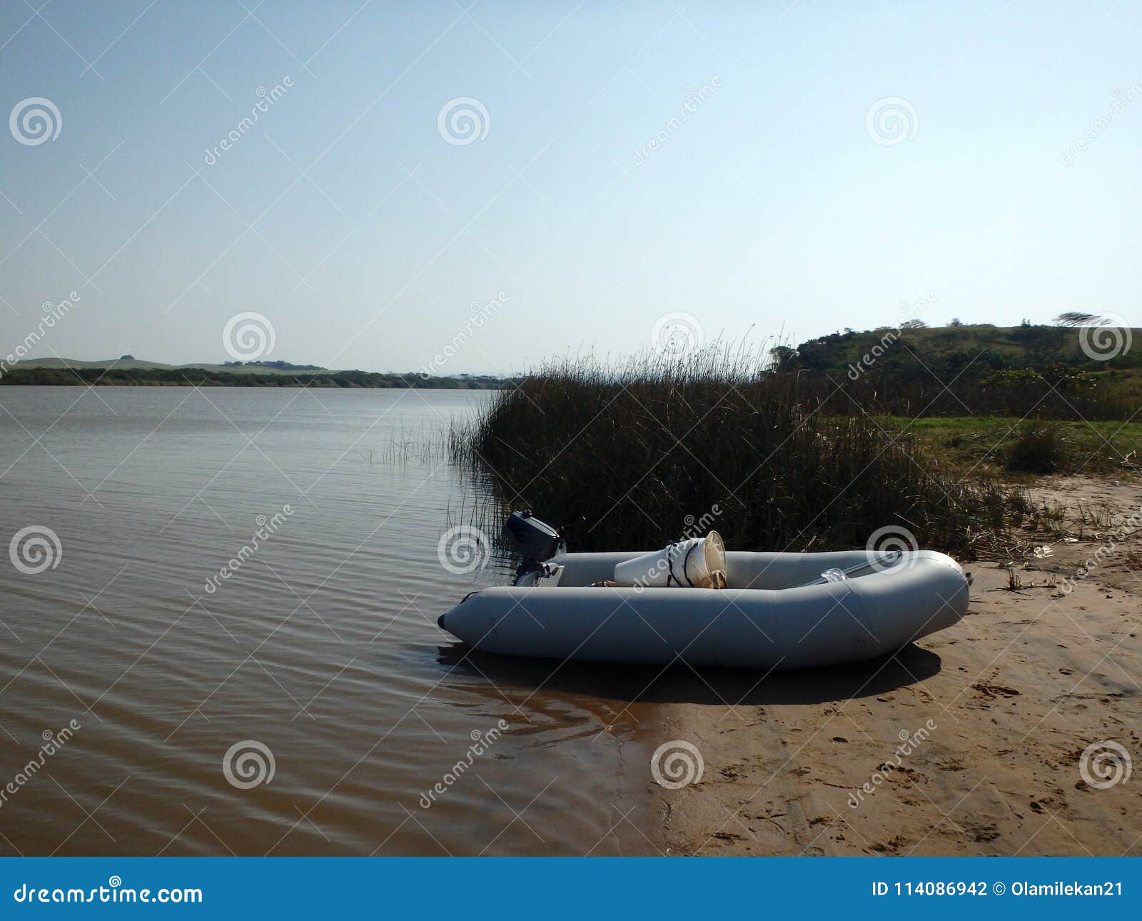 Inflatable boat on a river bank, ready to be launched into the river for a great adventure.