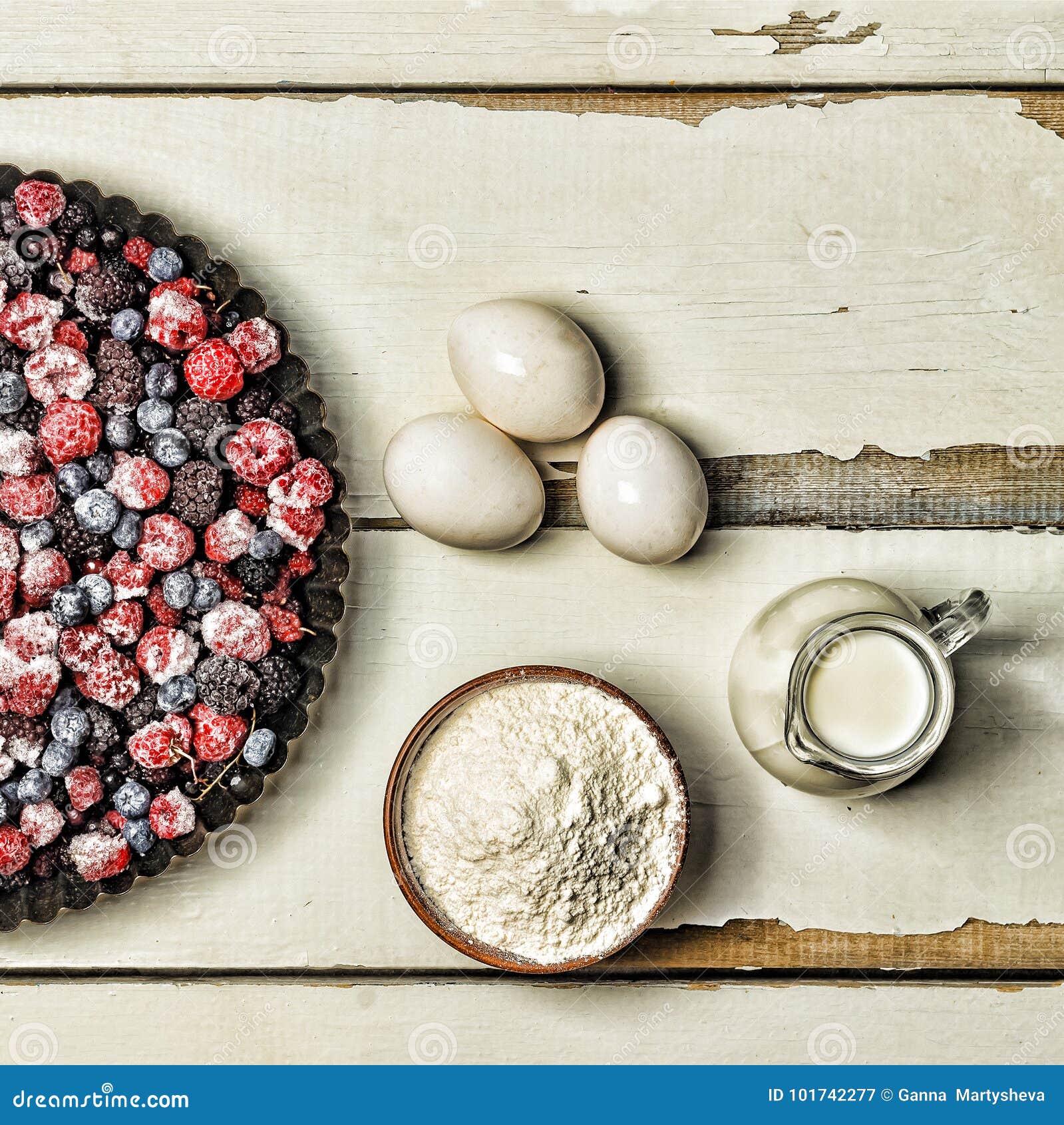 Frozen Berries, Flour, Eggs and Milk on a Rustic White Table