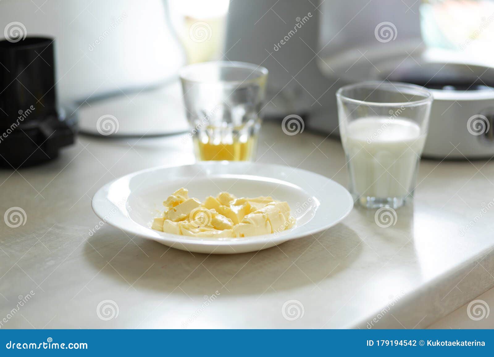 Ingredients for Making Sweet Cream. Butter Melts in a Plate Stock Photo