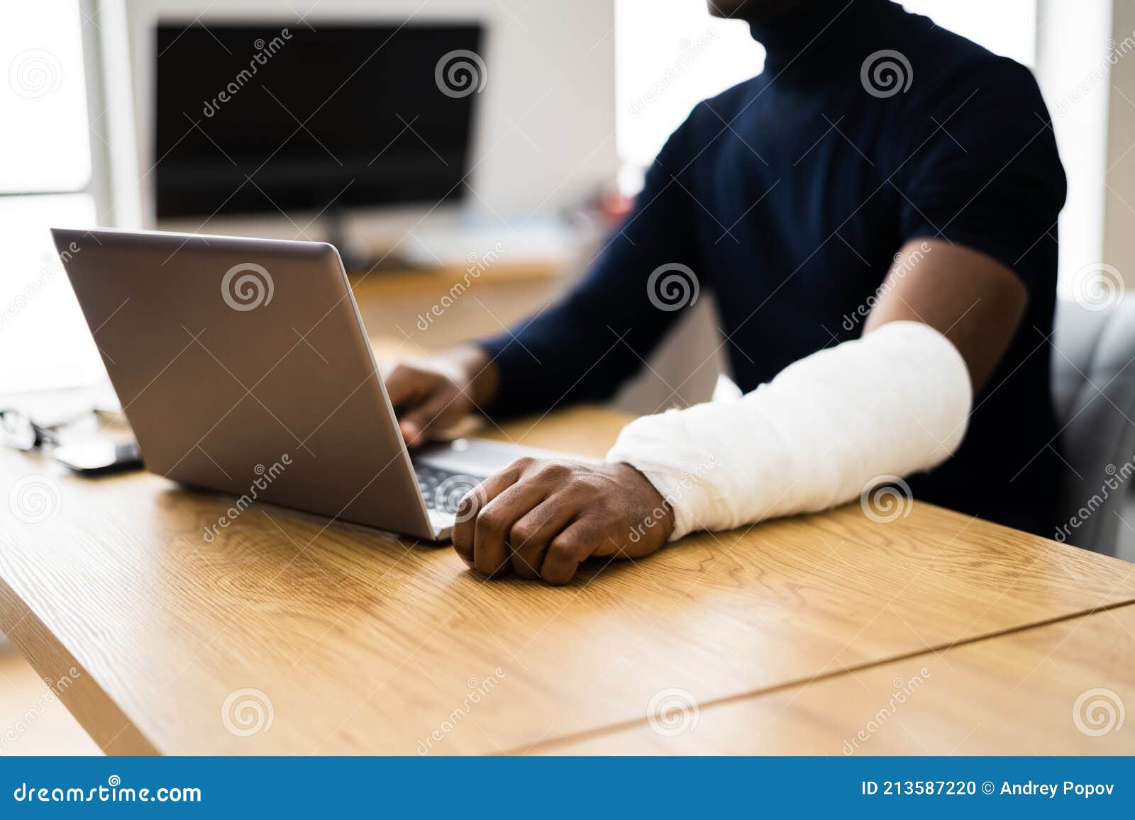 injured worker compensation. broken arm african man