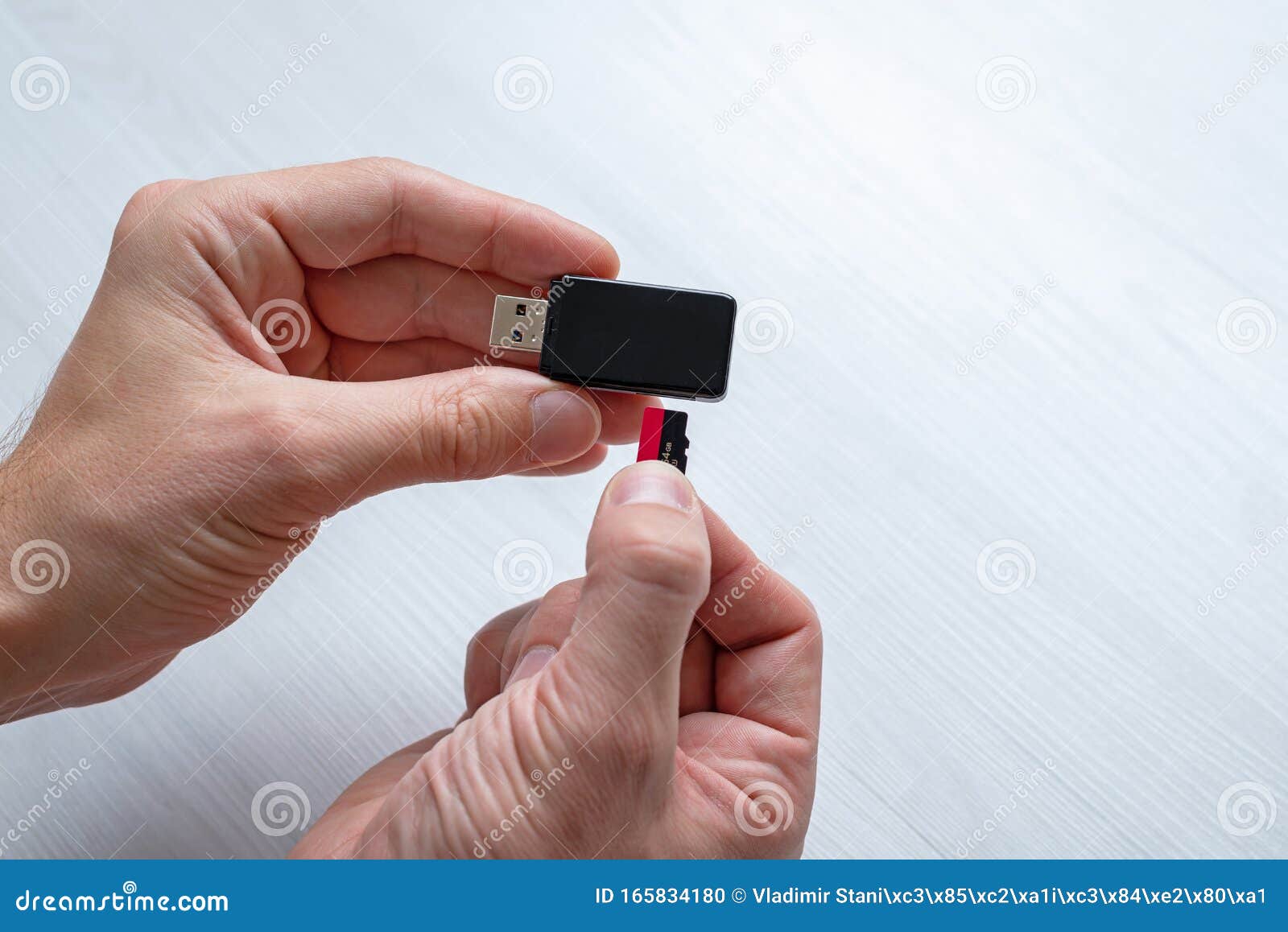 Inserting mini sd memory card in card reader concept hand holding