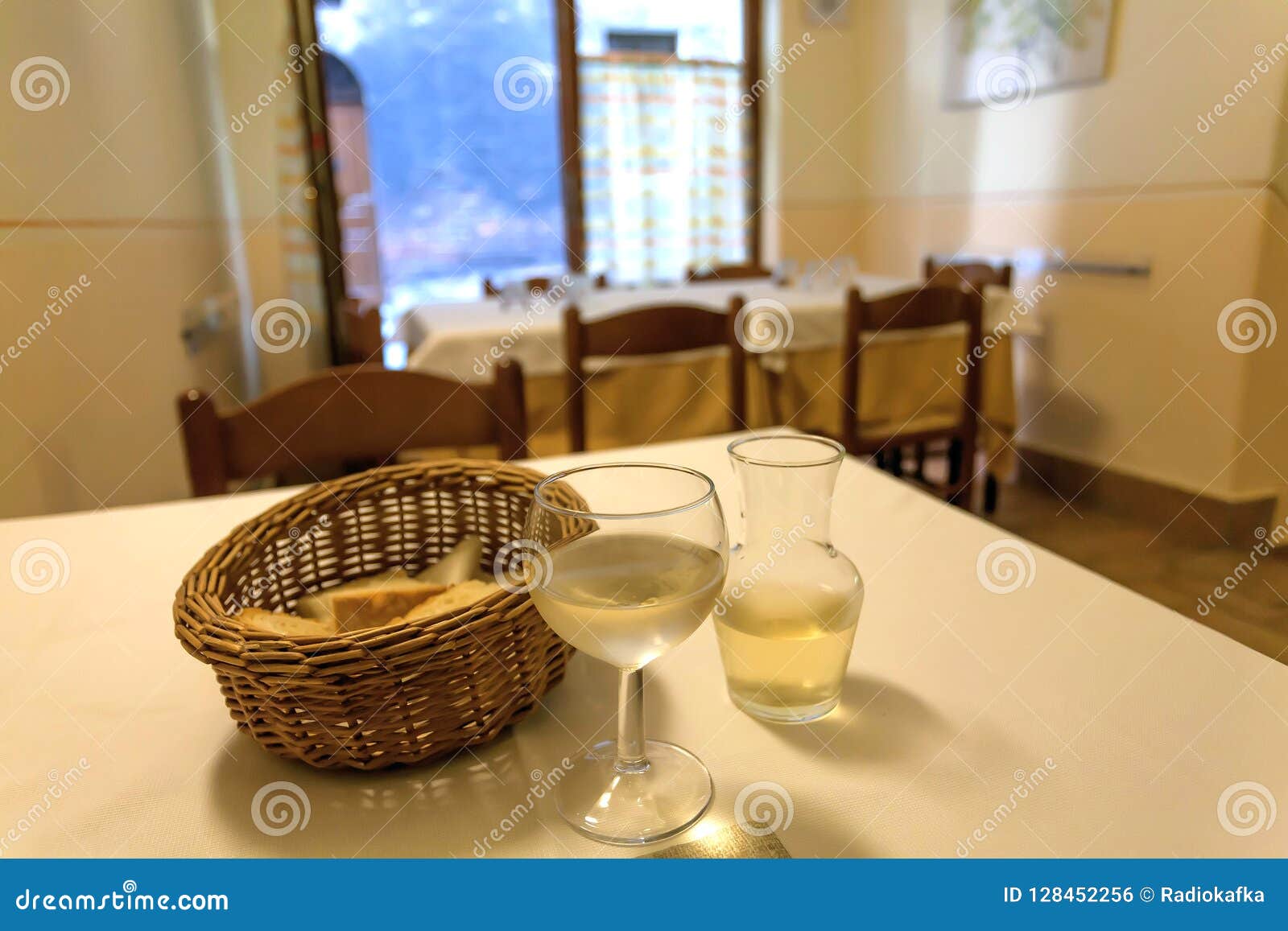 inside traditional italian trattoria. white wine on table of old restaurant with bread and drinks waiting for visitors