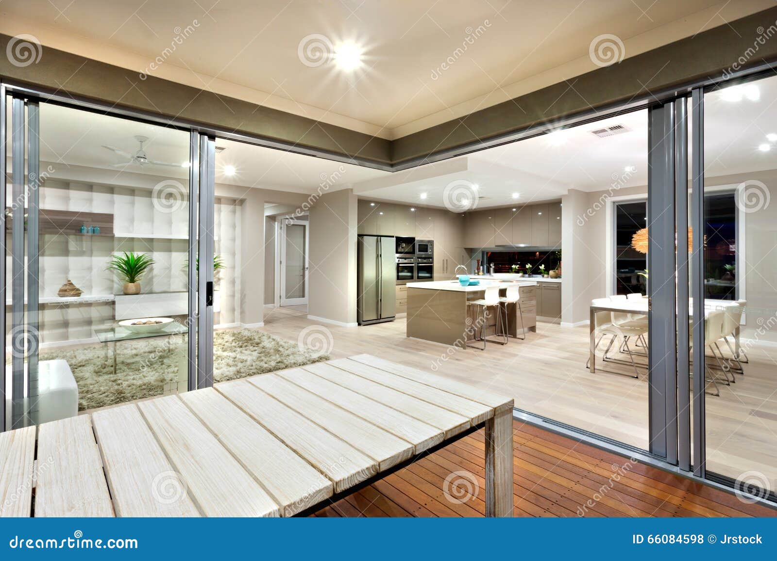 Inside view of a modern house lights turned on with wooden table
