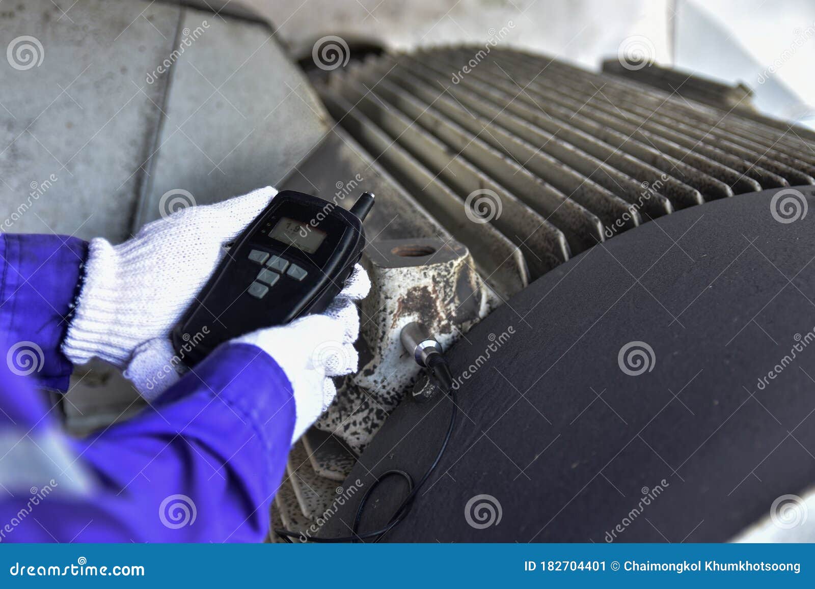 inspector using a handheld vibration tester