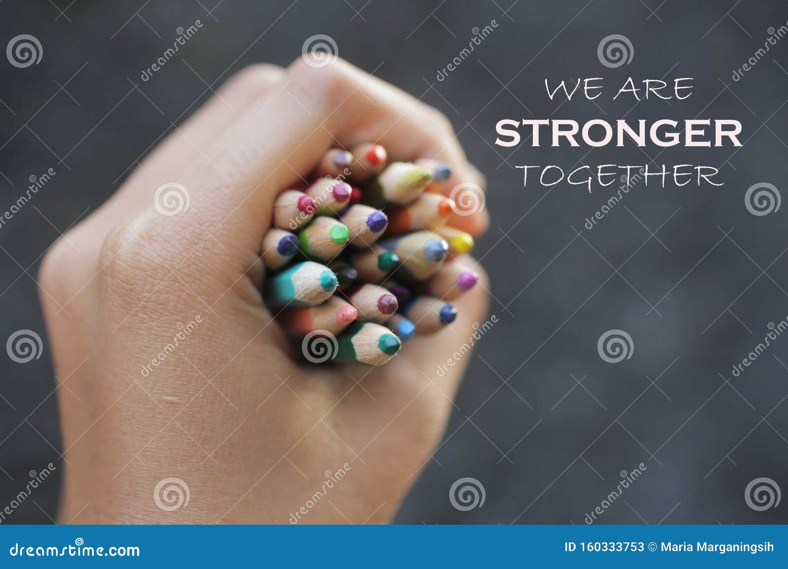 inspirational quote - we are strong together. with bunch of colored pencils in hand.
