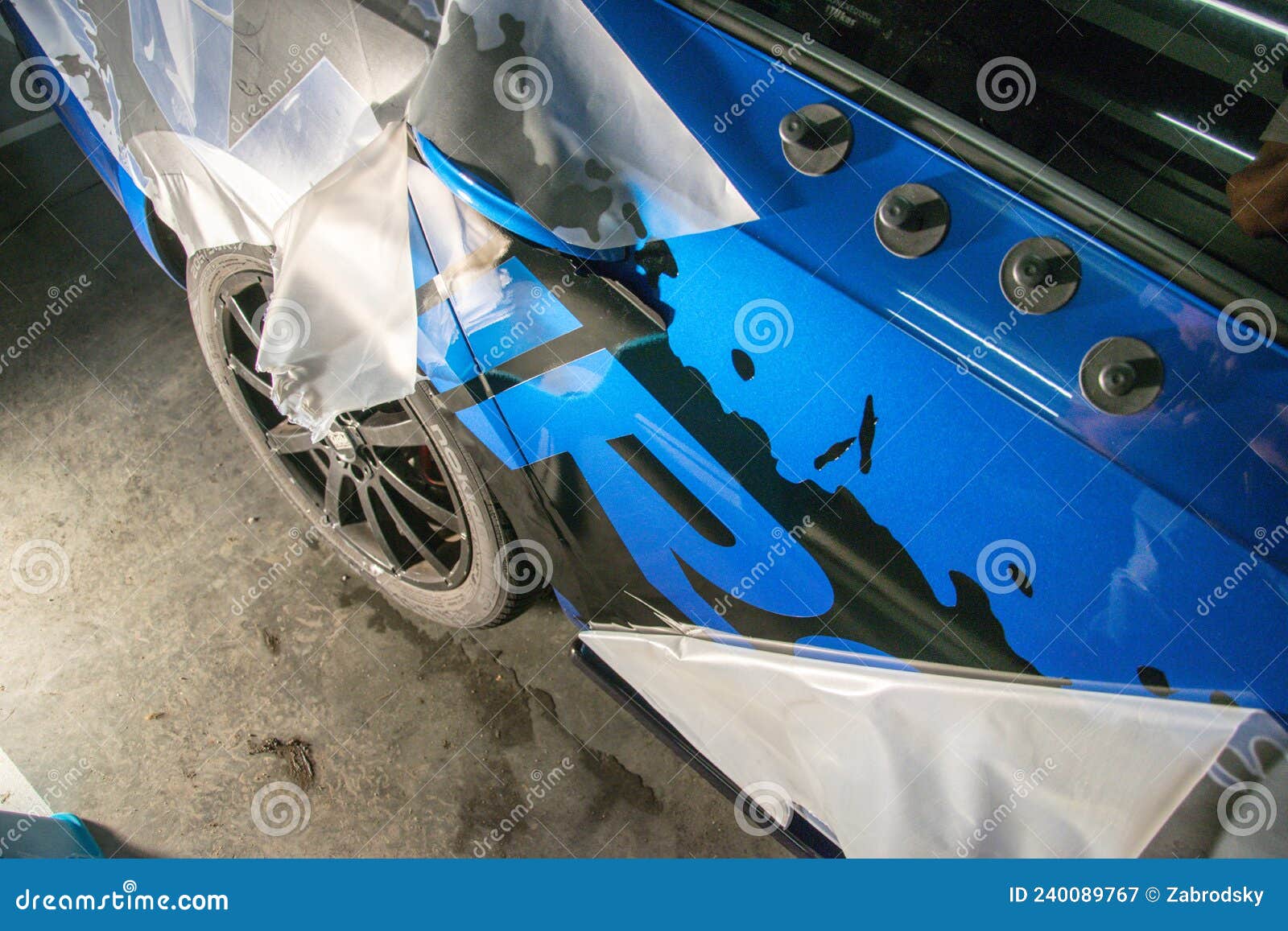 Instalación De Pegatinas De Brillo De Vinilo Negro En Un Lado De Un Coche  Deportivo Azul Estacionado En Un Garaje. Fotografía editorial - Imagen de  transporte, automotor: 240089767