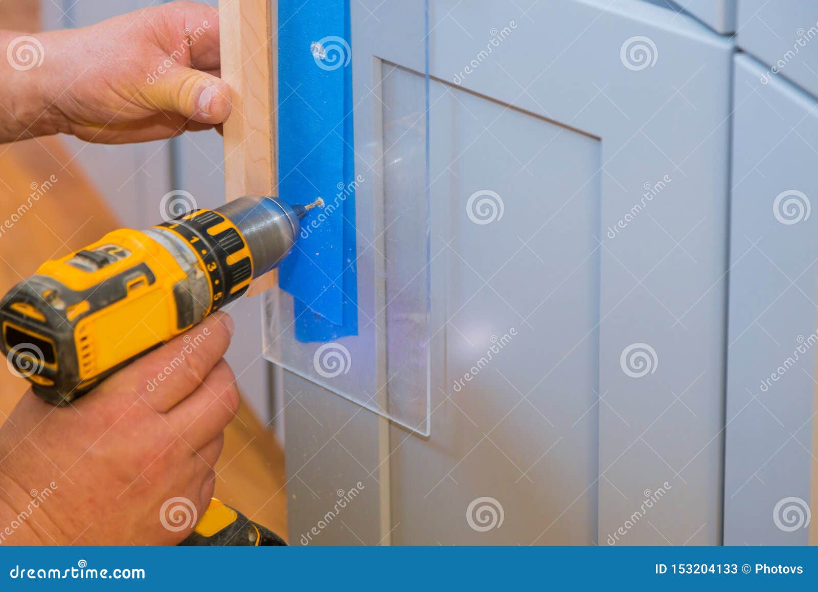 Master Drills The Cabinet Door In The Cabinet Door Stock Image