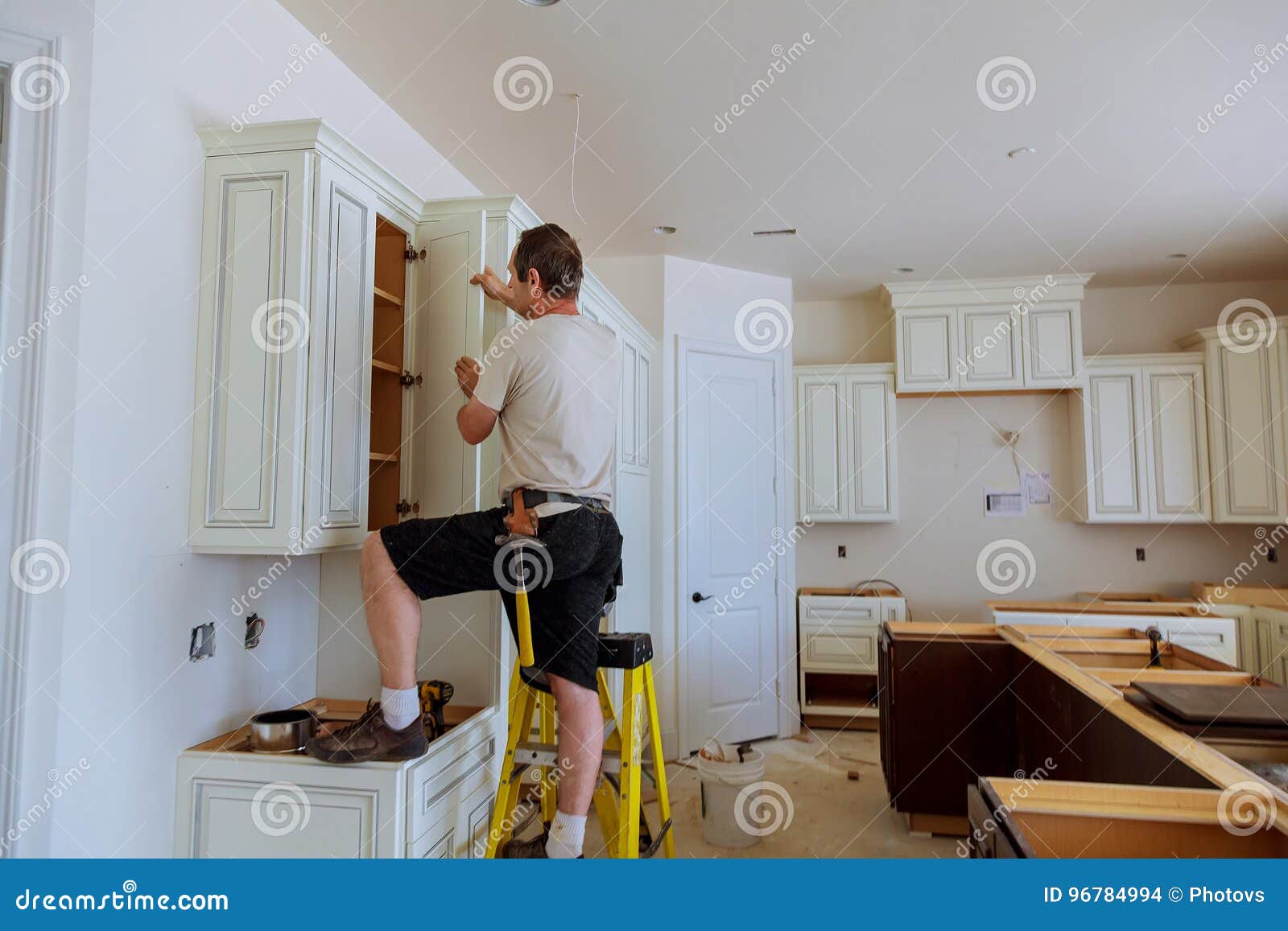 Installation Of Kitchen Worker Installs Doors To Kitchen Cabinet