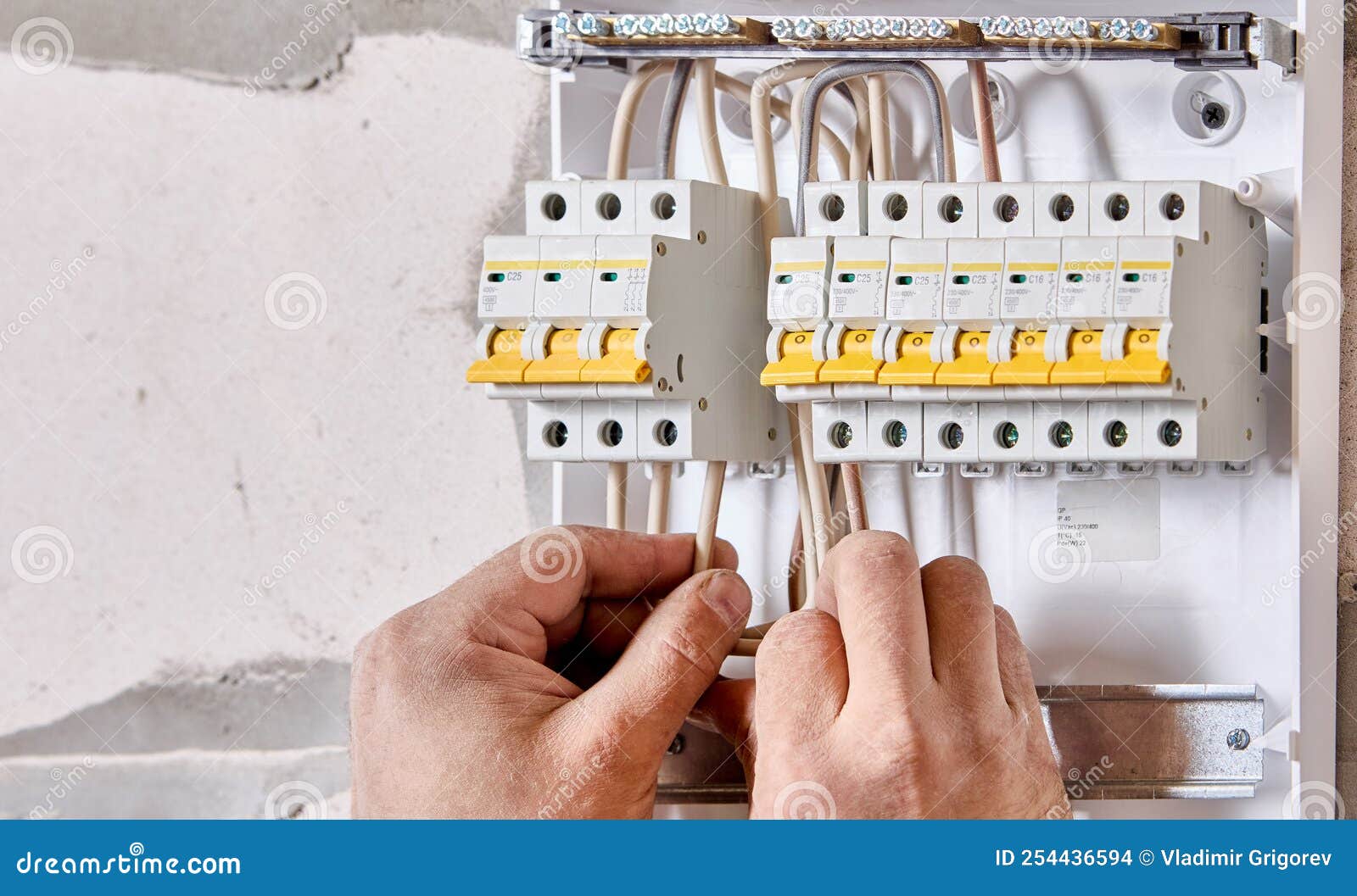 An Electrician Connects Wires To Fuse Box in Consumer Unit of