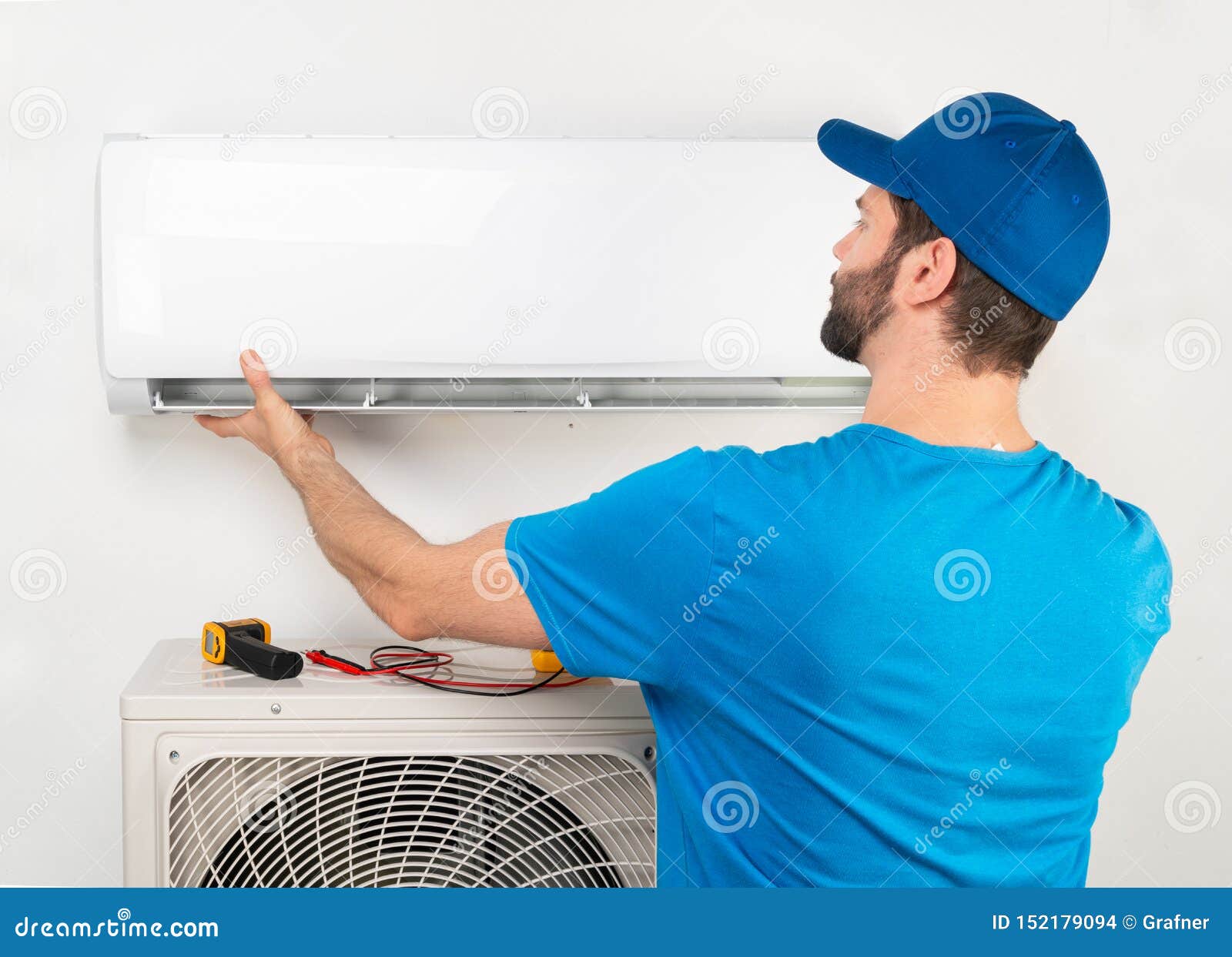 installation service fix  repair maintenance of an air conditioner indoor unit, by cryogenist technican worker in blue shirt