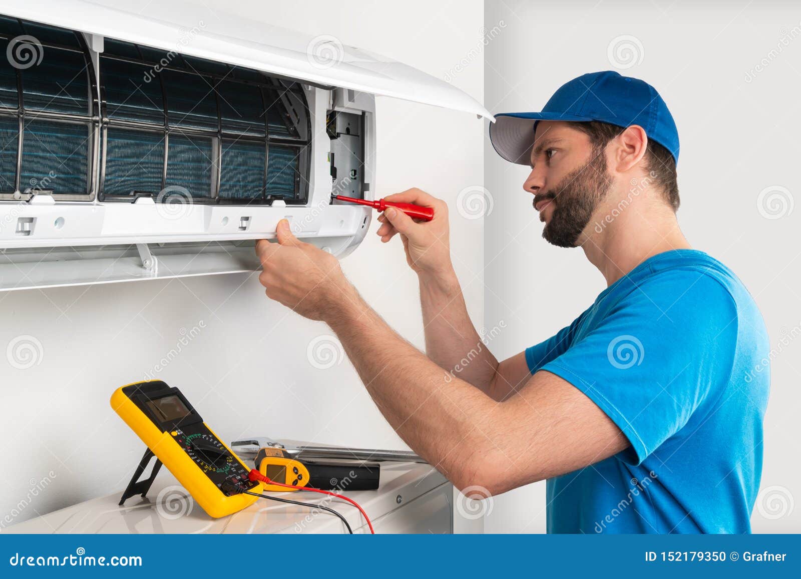 installation service fix  repair maintenance of an air conditioner indoor unit by cryogenist technican worker with screwdriver