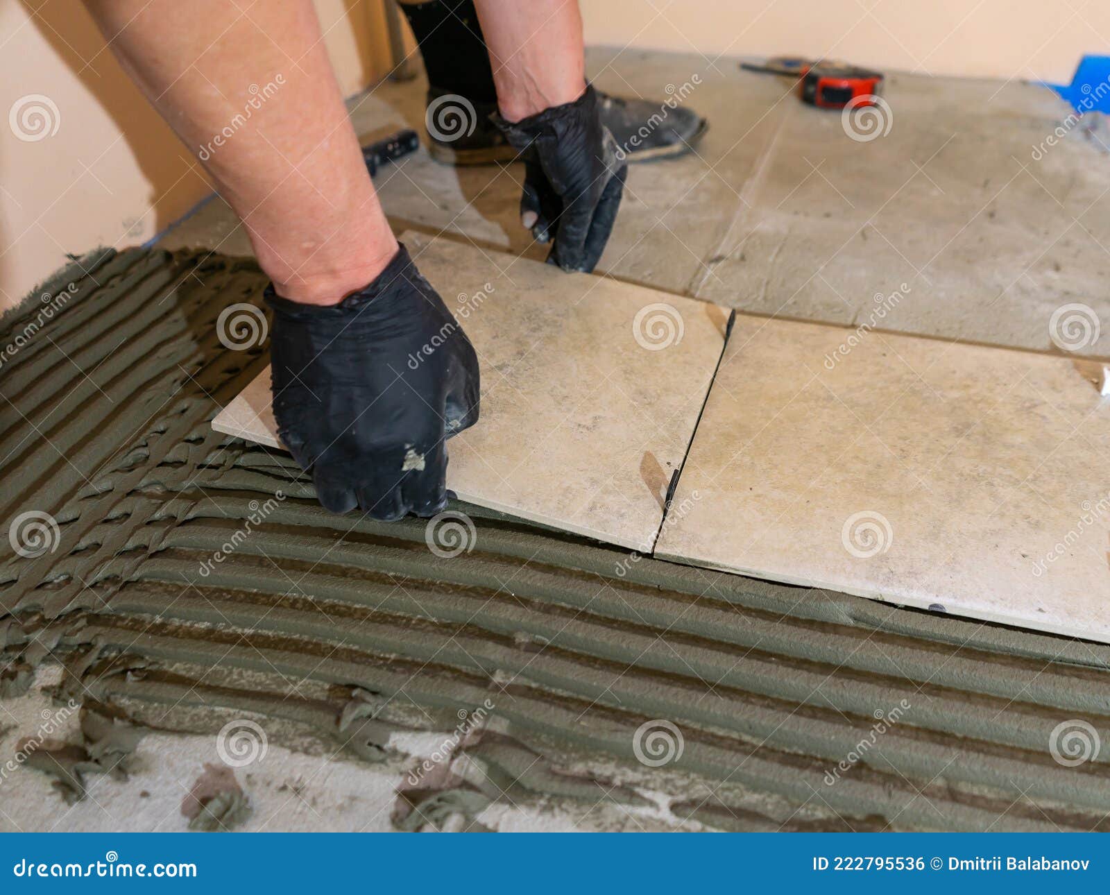 Installing Ceramic Floor Tiles Placing the Tile into the Adhesive Material Bedding, Closeup