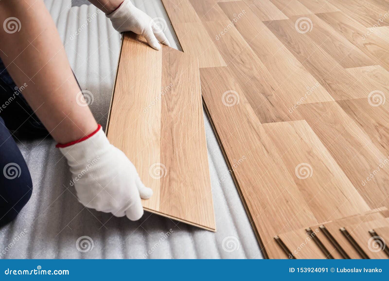 Installing Laminated Floor Detail On Man Hands With White Gloves