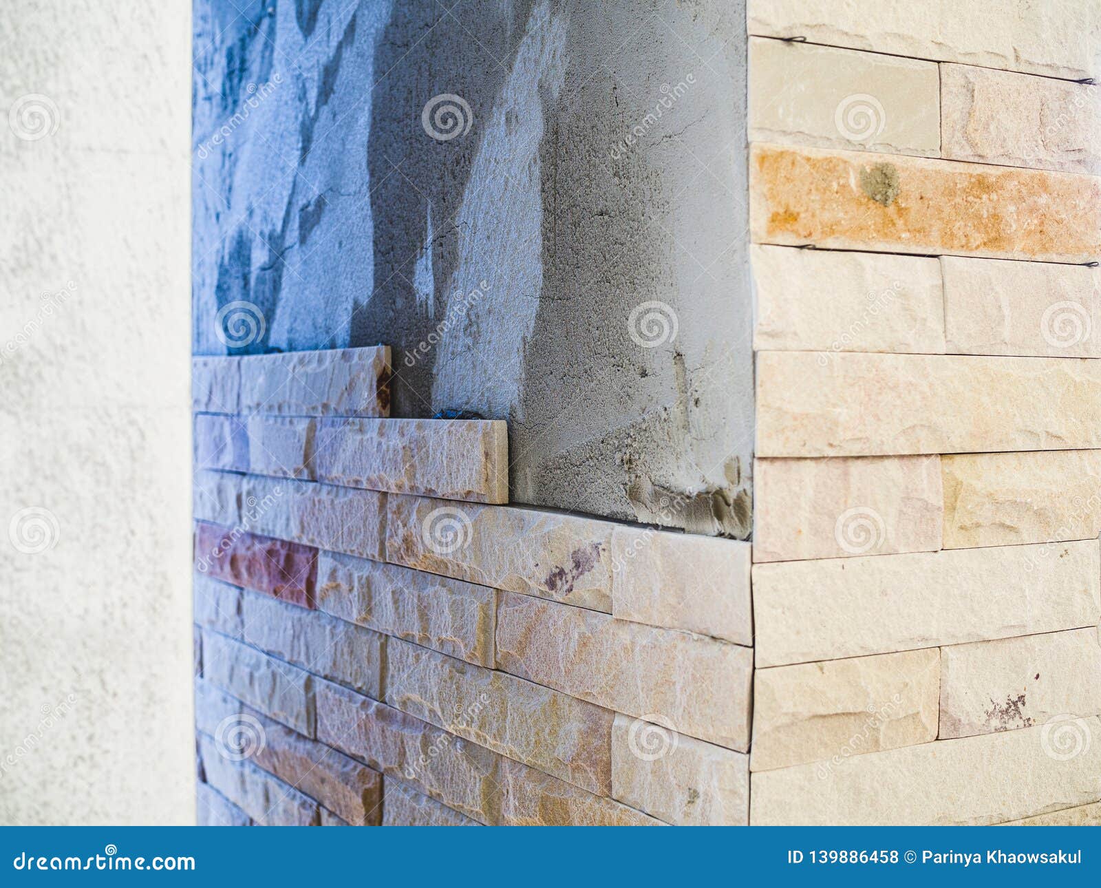 Installing Sandstone Decorative Tiles on the Pillars House Stock Photo