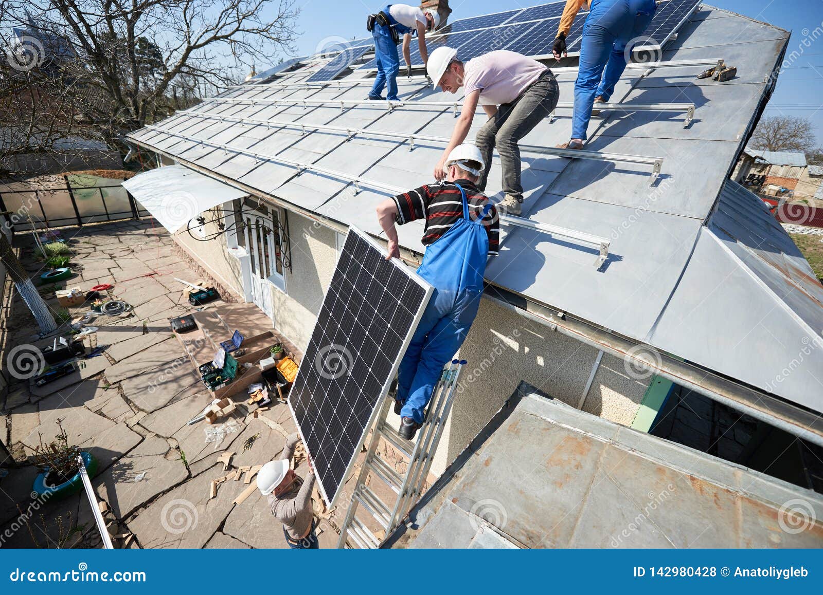 Installing Solar Photovoltaic Panel System On Roof Of House Stock Photo How To Lift Solar Panels Onto Roof