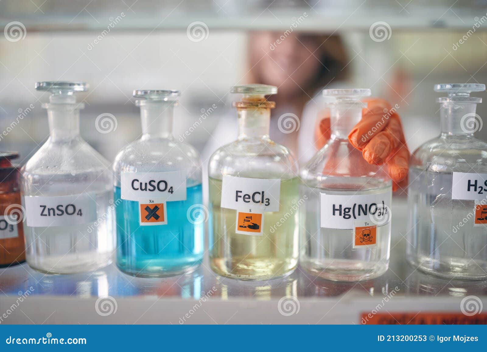 an institution employee handling bottles with chemicals in the laboratory. chemistry, chemicals, lab