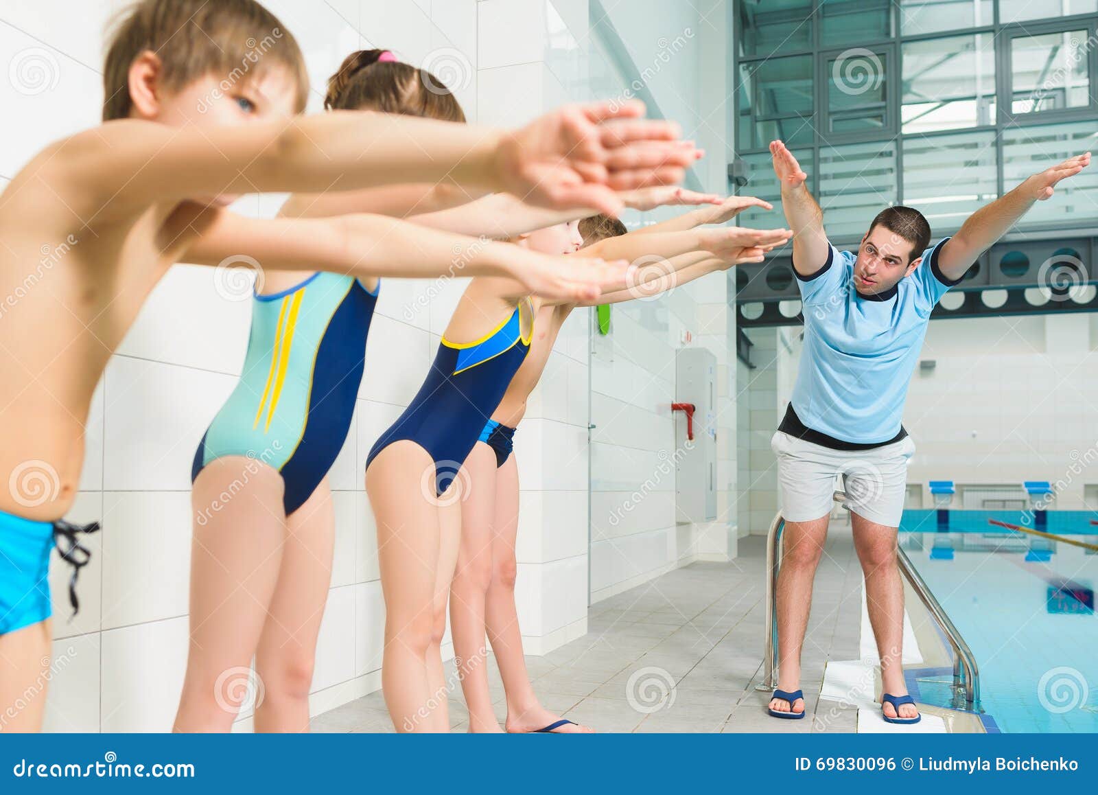 Instructor and Group of Children Doing Exercises Near a Swimming Pool