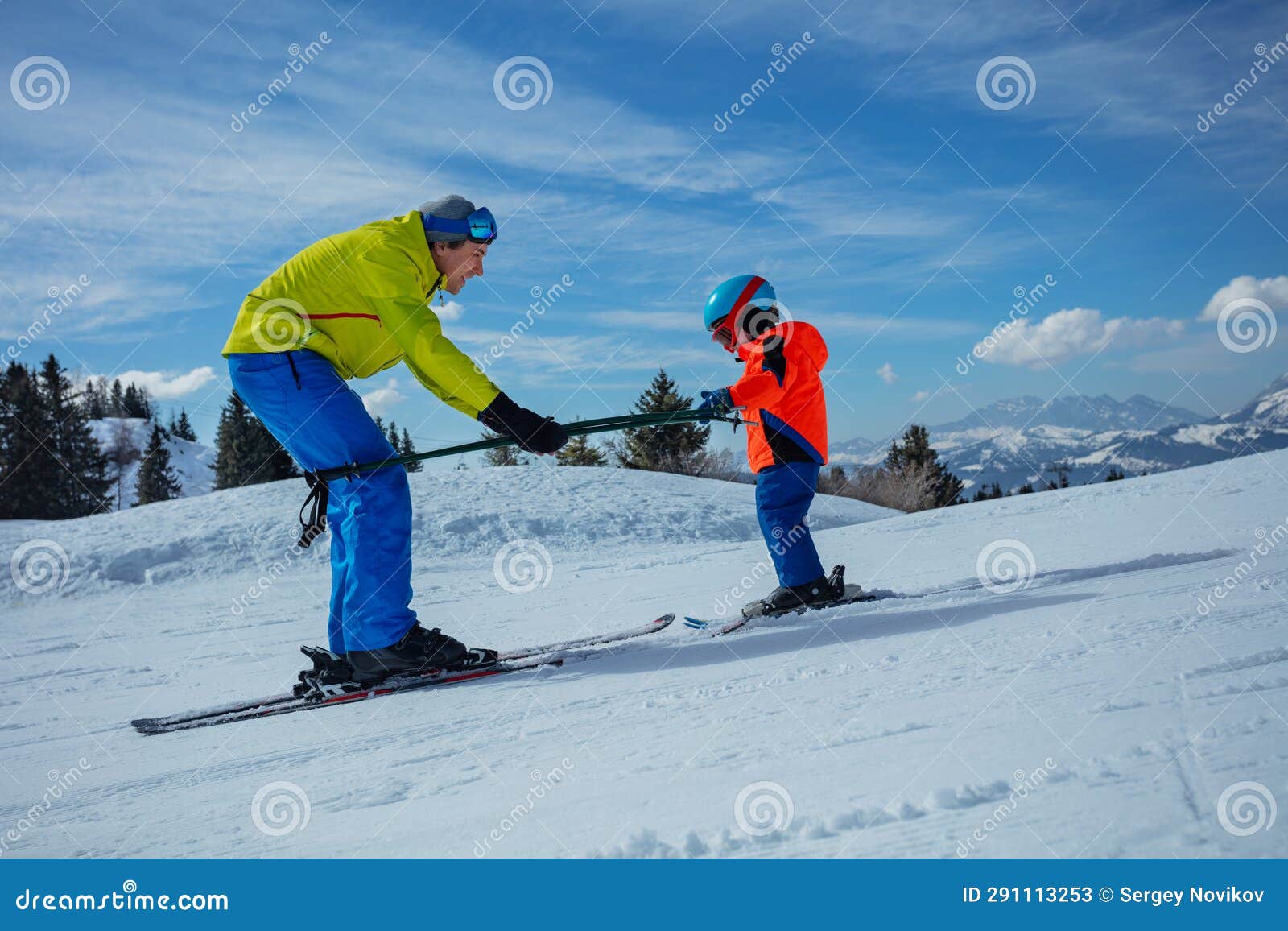 instructor in skiing school glide backwards teach child to ski