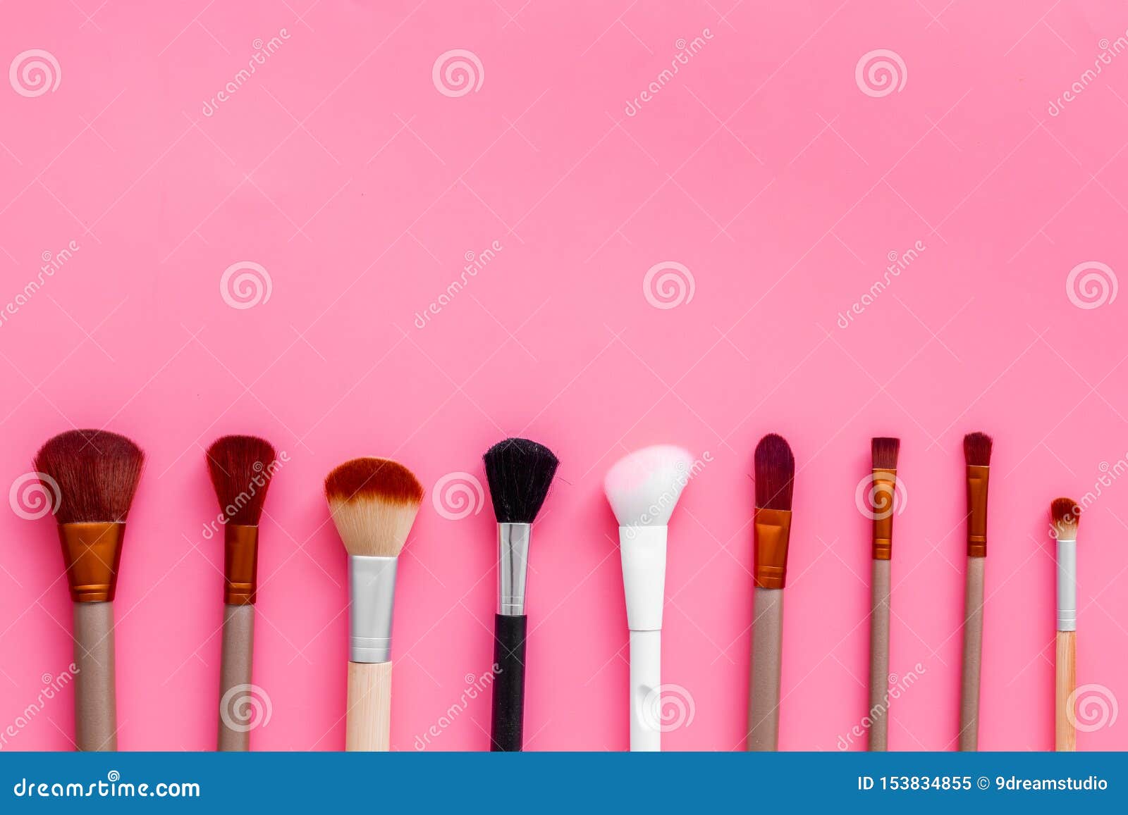 instruments for make up with brushes on pink background top view mock up