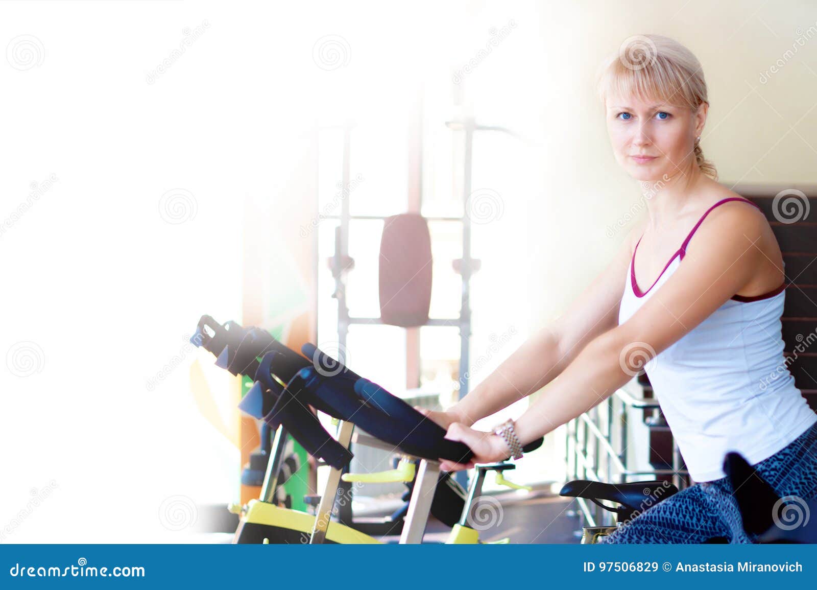 Instrutor da bicicleta da mulher da aptidão no gym interno