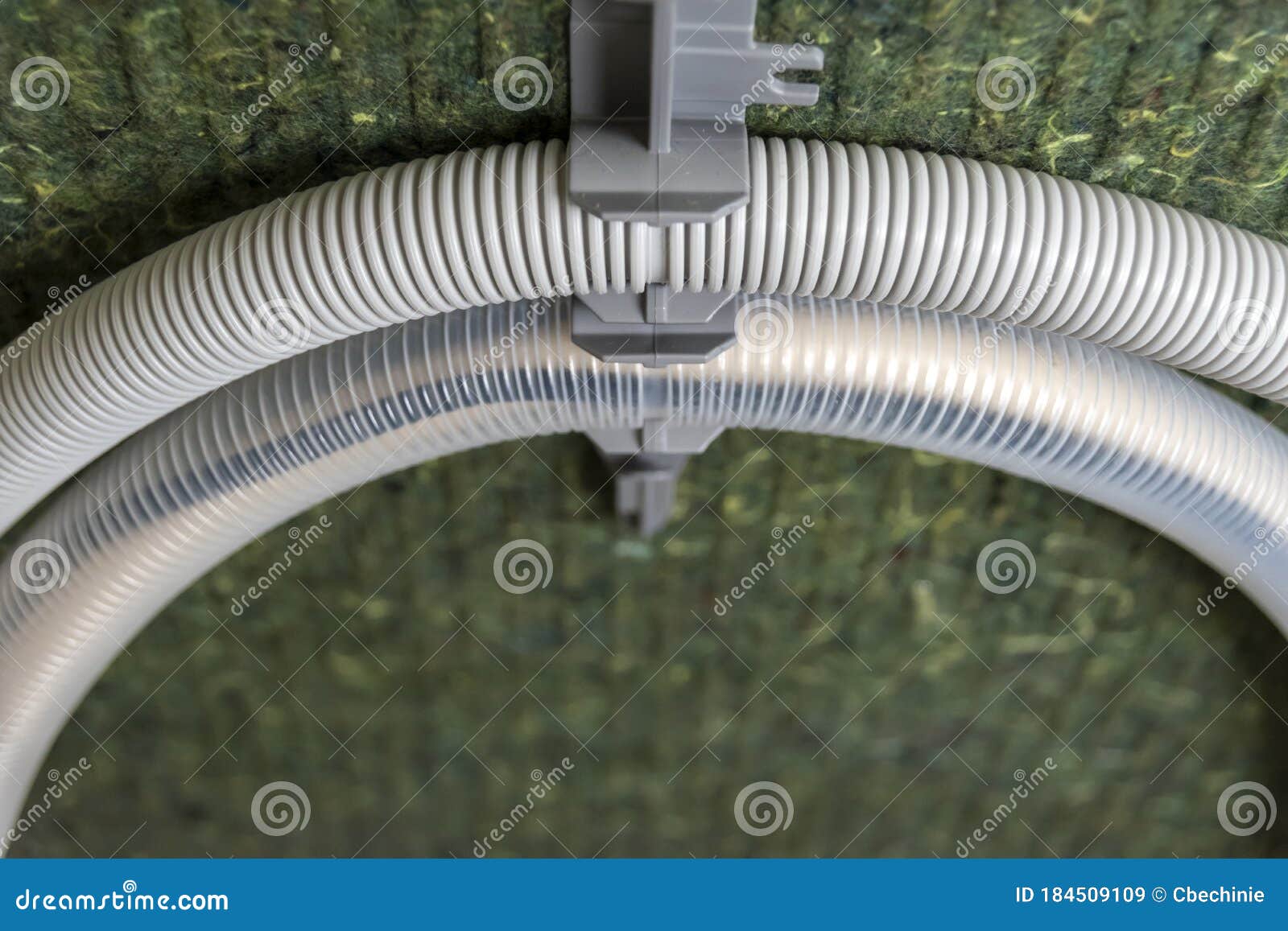 Insulated Back of a Dishwasher with Two Rolledup Water Hoses Stock
