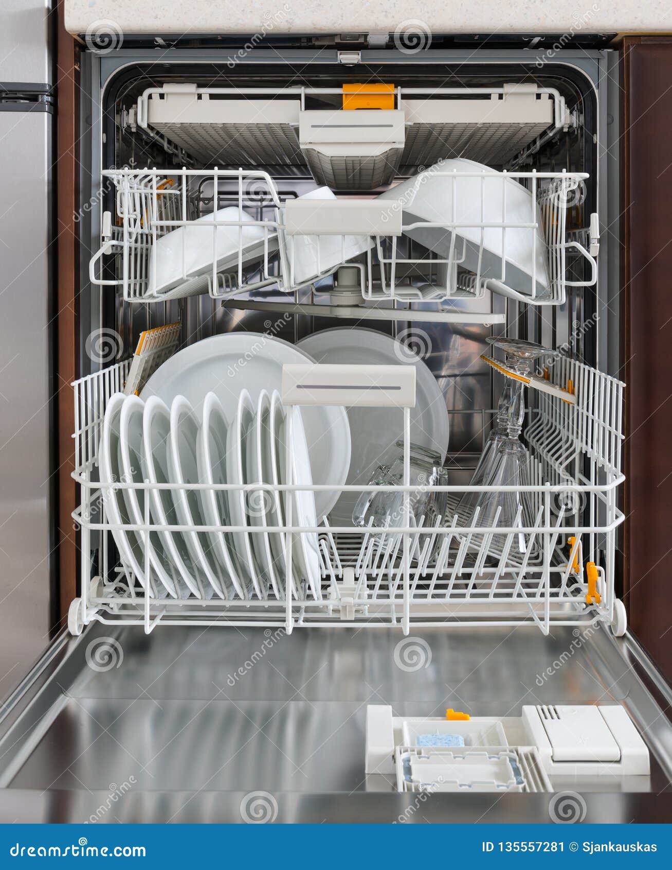 Integrated Dishwasher with Dishware in a Kitchen. Home Appliances Stock