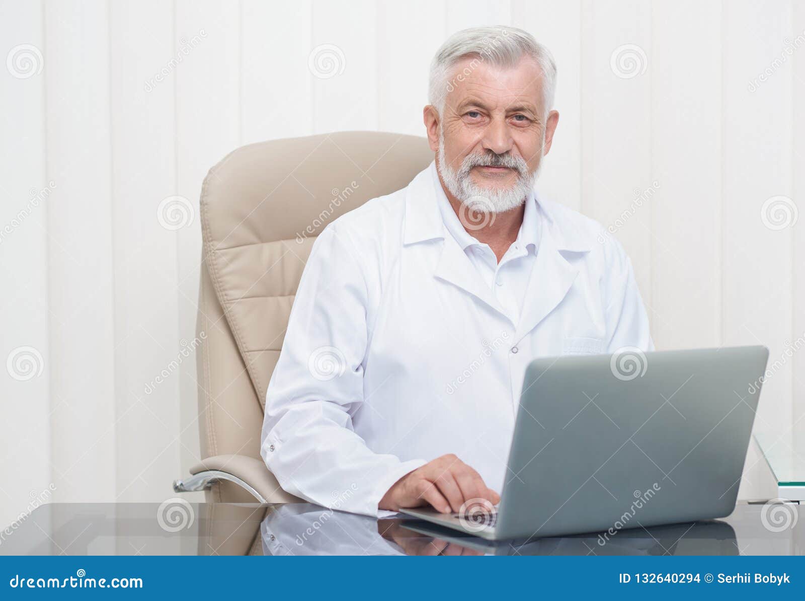 Intelligent Senior Doctor Working on Laptop in Office. Stock Photo ...