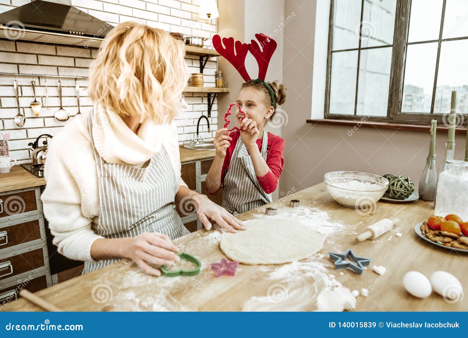 interacted beaming child in red dress showing plastic form to her