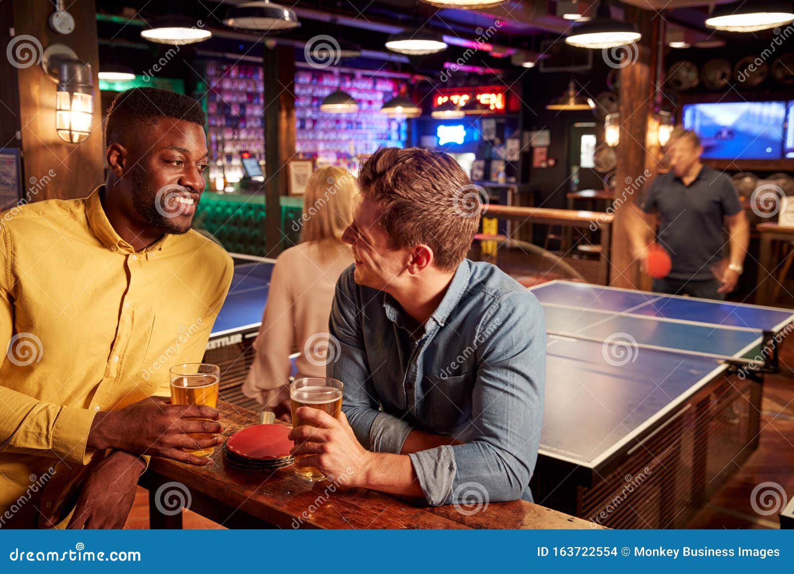 Interior of Bar with Customers Drinking and Playing Table Tennis Stock