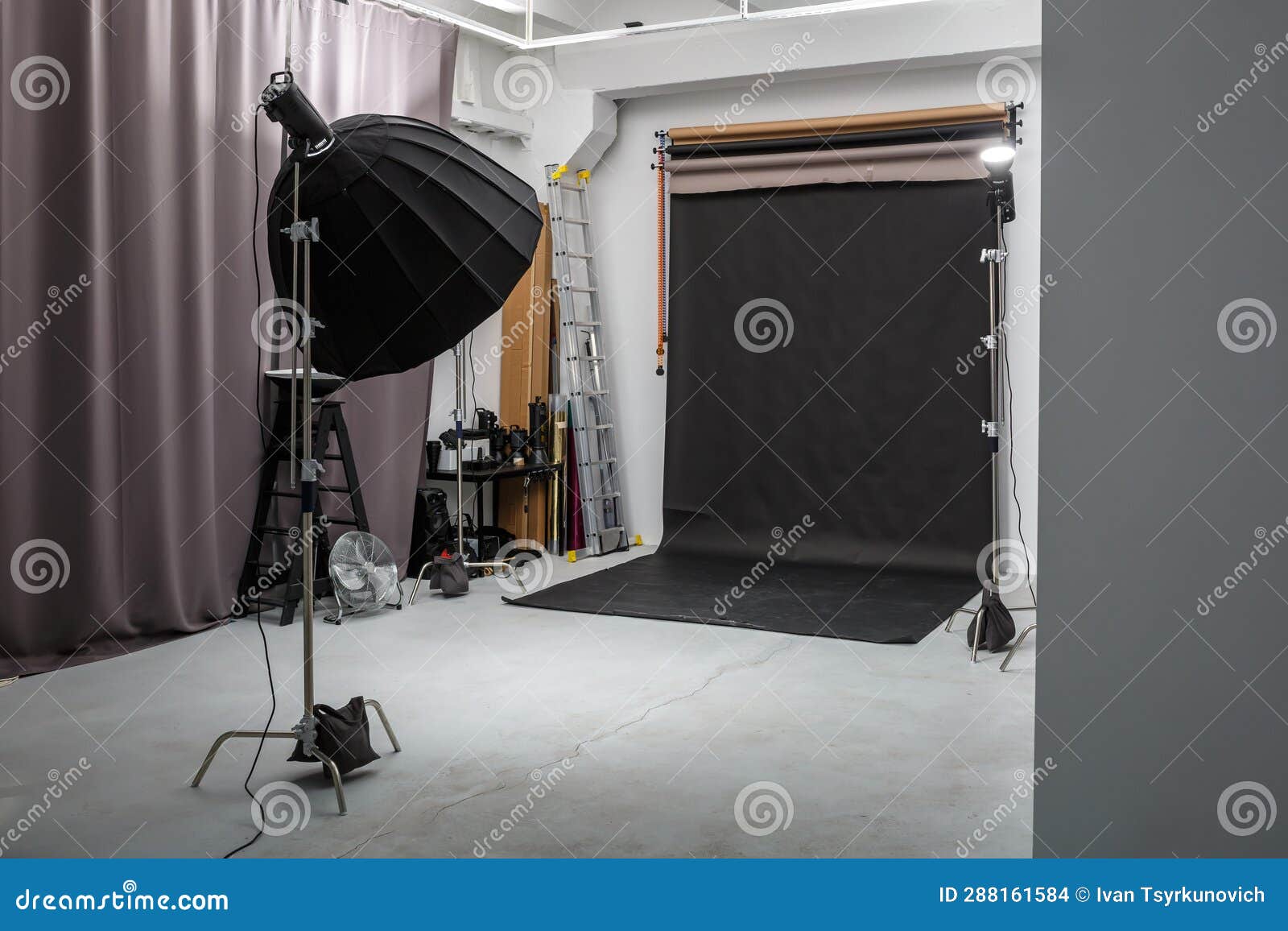 Interior of Bright Space of Photo Studio with Large Black Background and Lighting Equipment