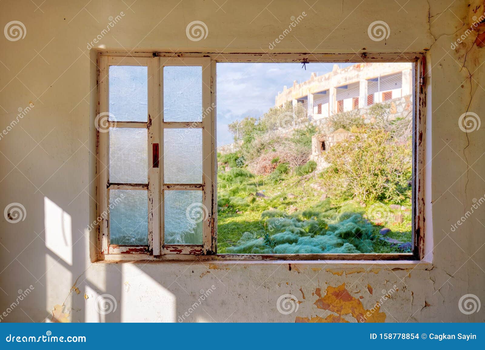 interior of a desolated house and a window frame with broken glass