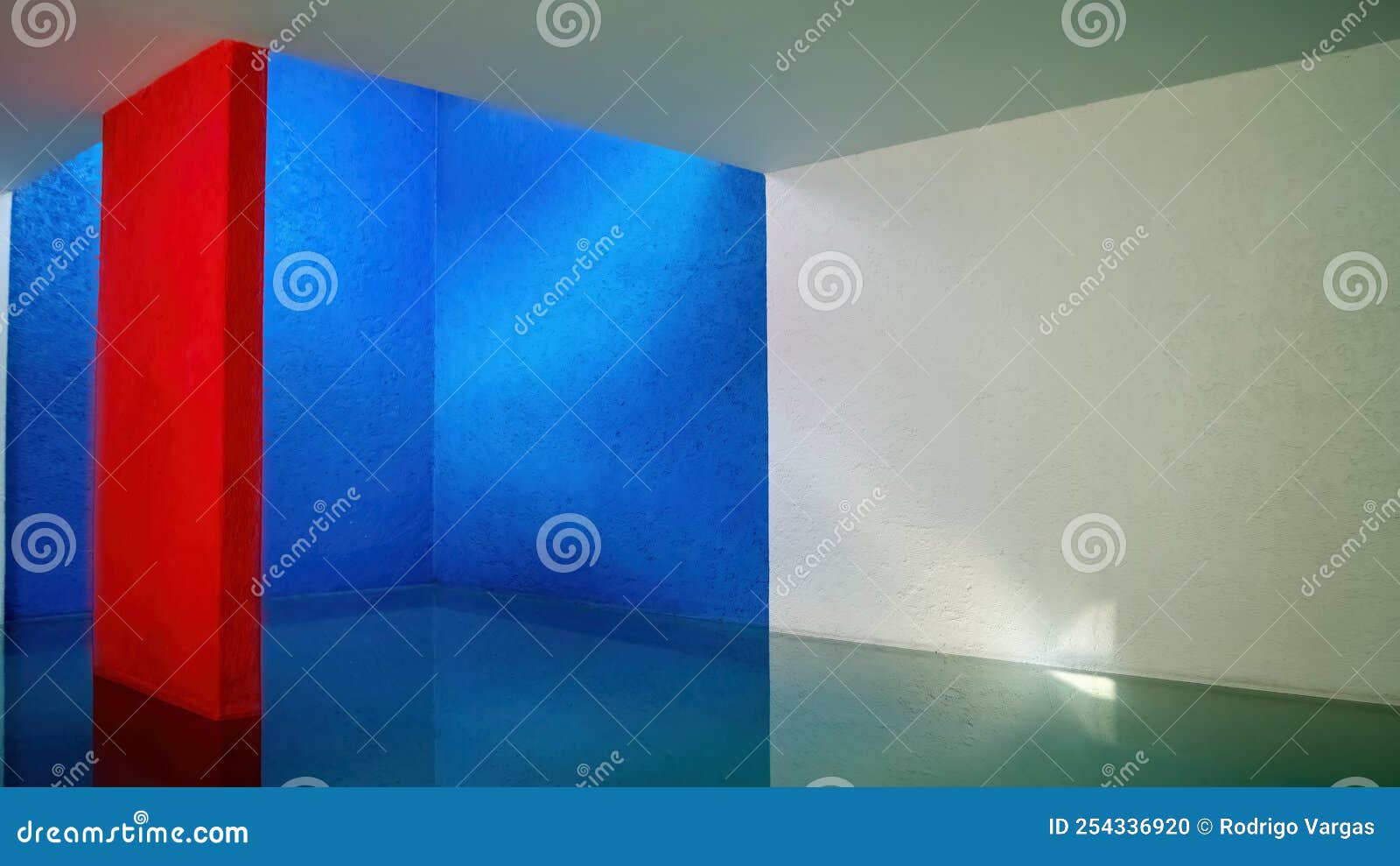 interior of the gilardi house of the famous architect luis barragan, pool reflecting the light, blue wall and red column